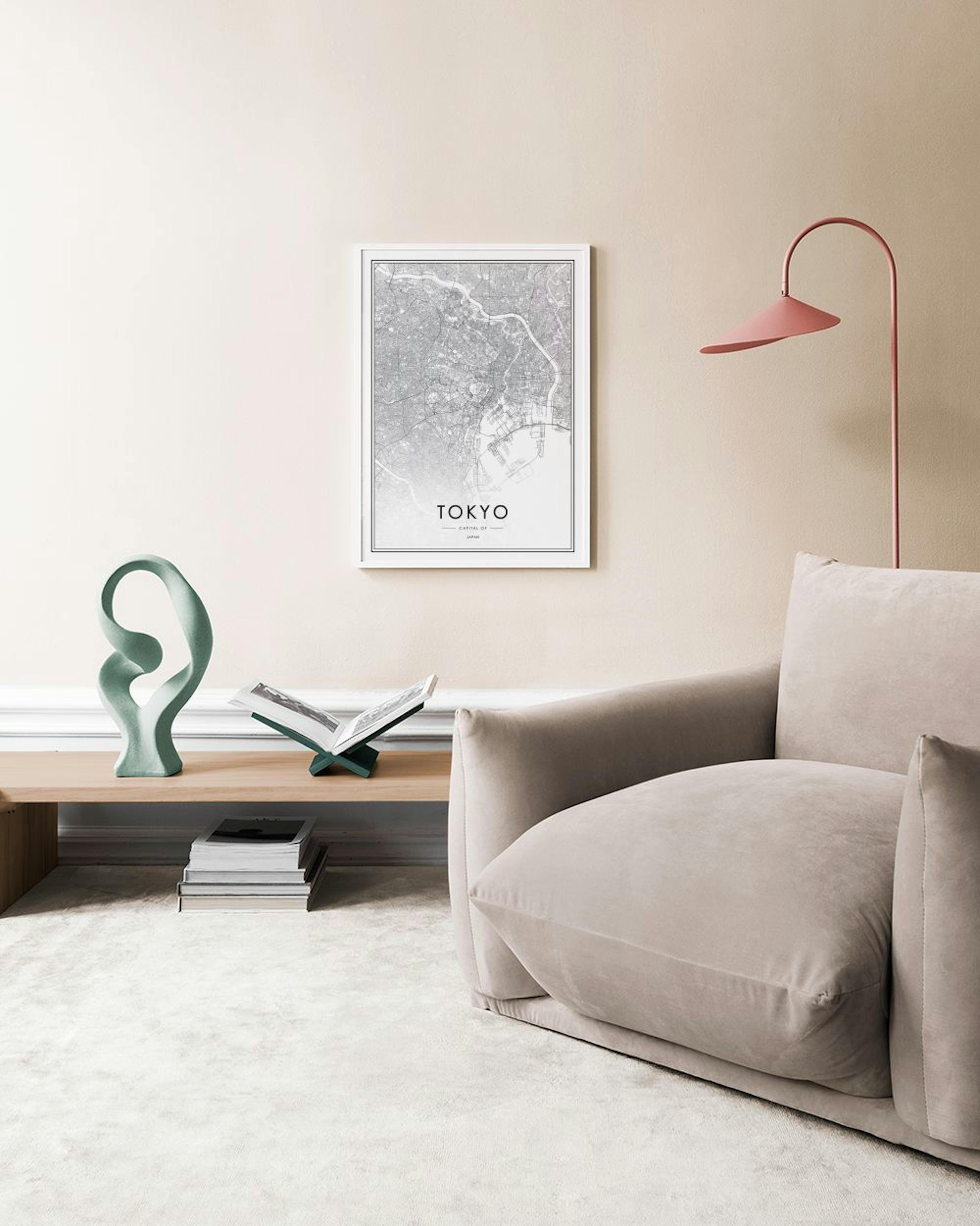 A black and white Tokyo map print displayed on a white surface with a cactus and a candle.