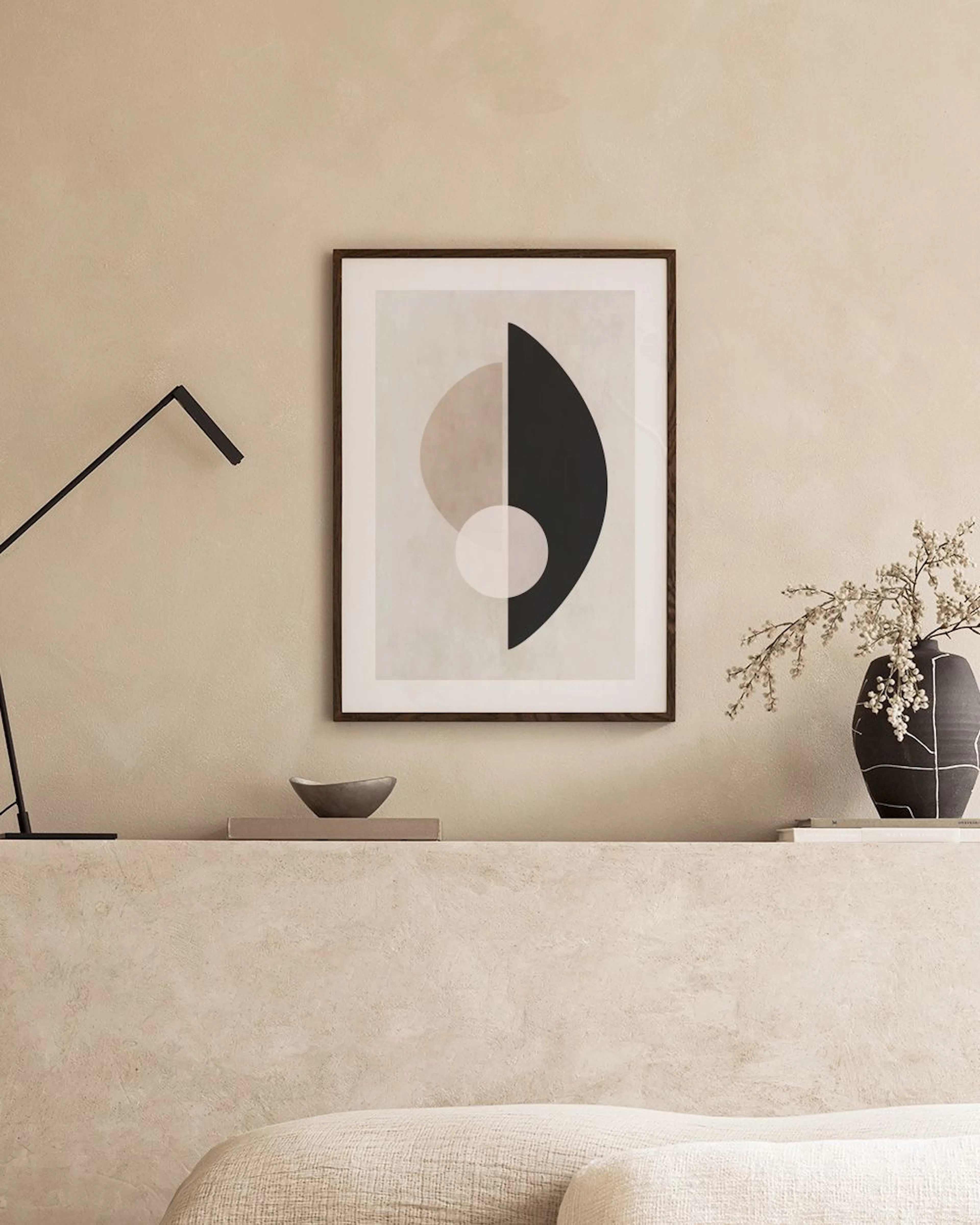 Affiche abstraite aux formes géométriques noires et beiges, accrochée dans un salon moderne.