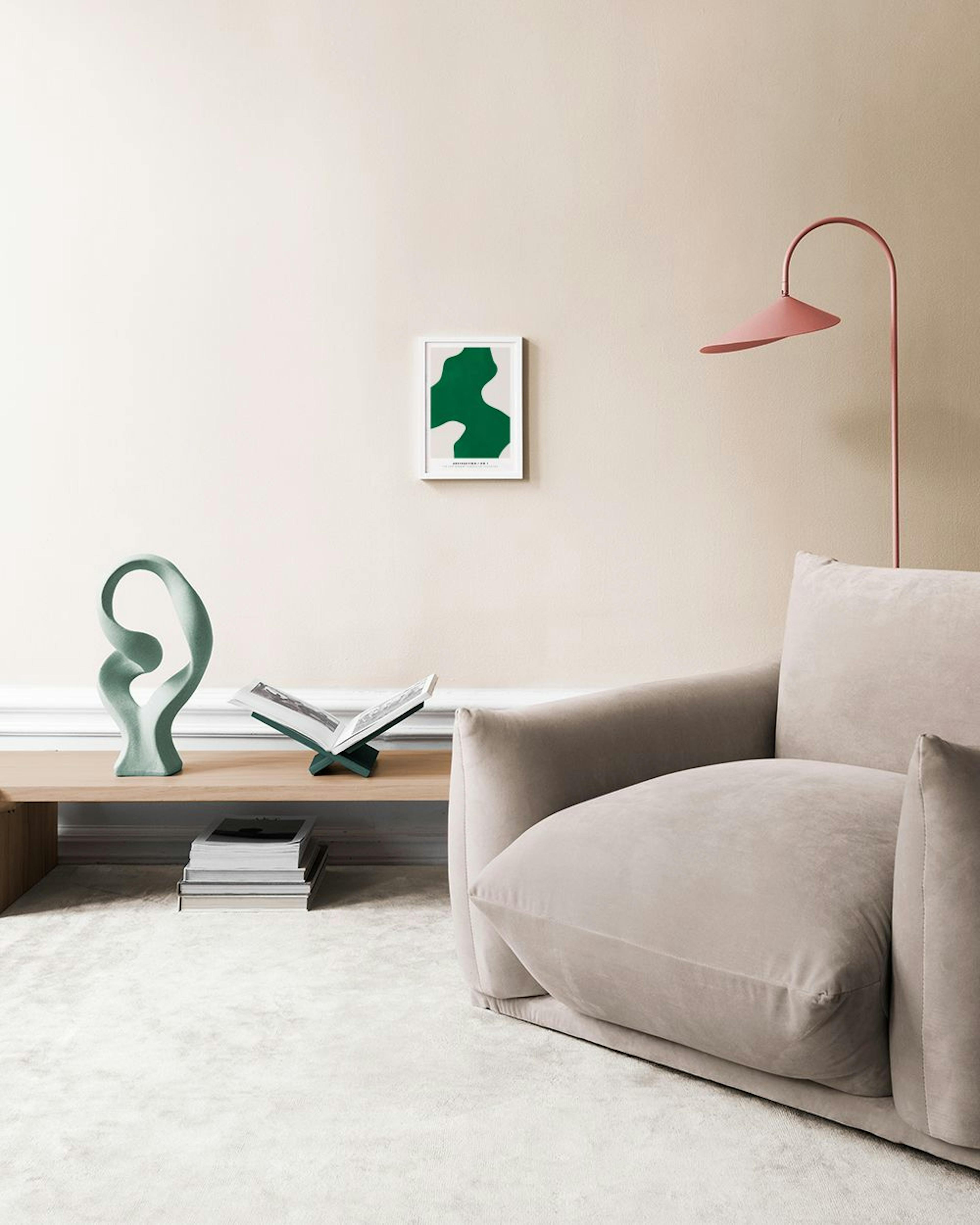 Poster met groene organische vormen op een lichte achtergrond, hangend boven een wit dressoir met vazen en een boek.