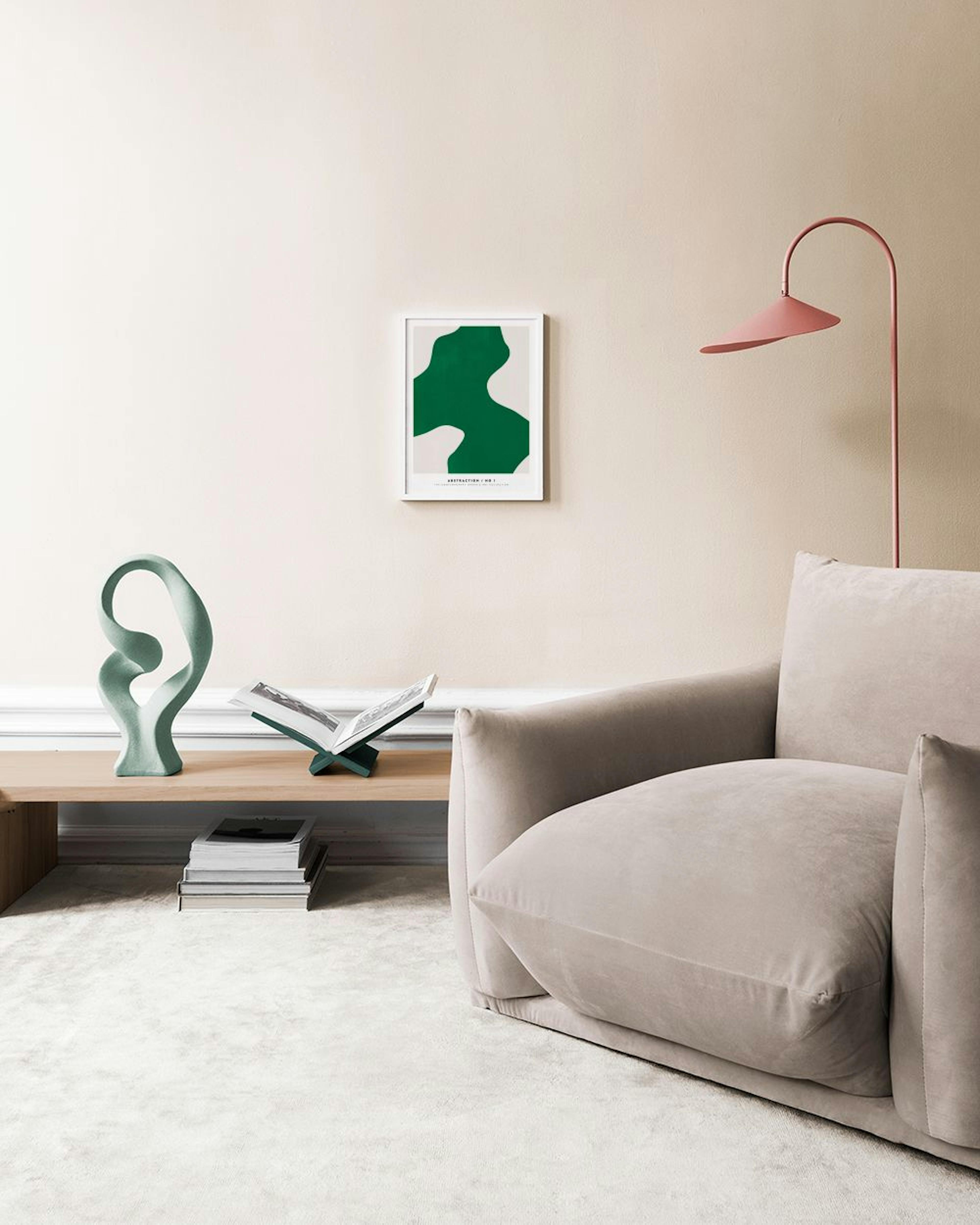 A green and off-white abstract print with organic shapes, hanging above a white console table with three vases and a green book.