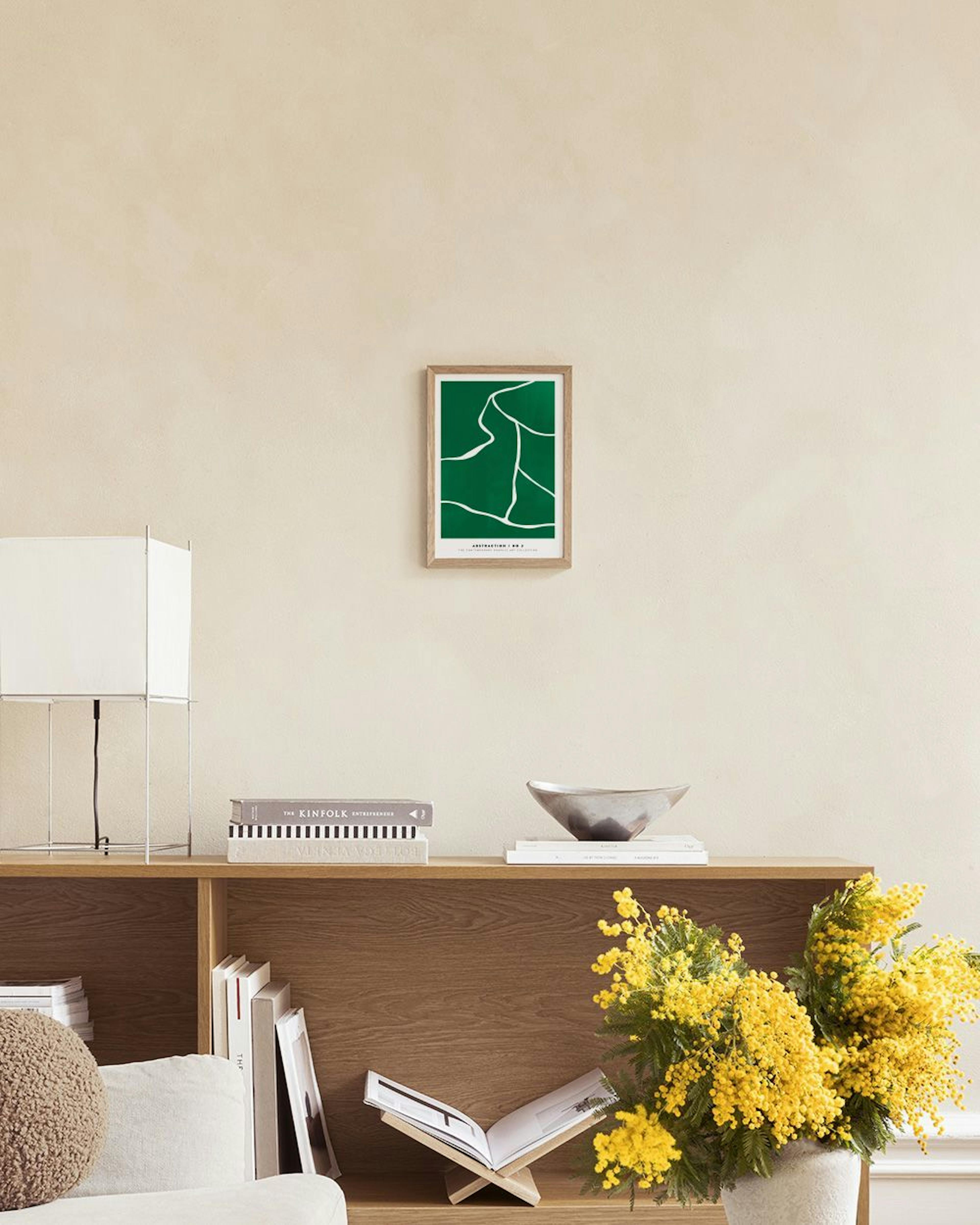 Plakat med grønne og hvite organiske former, henger over en grønn puff i et moderne rom.