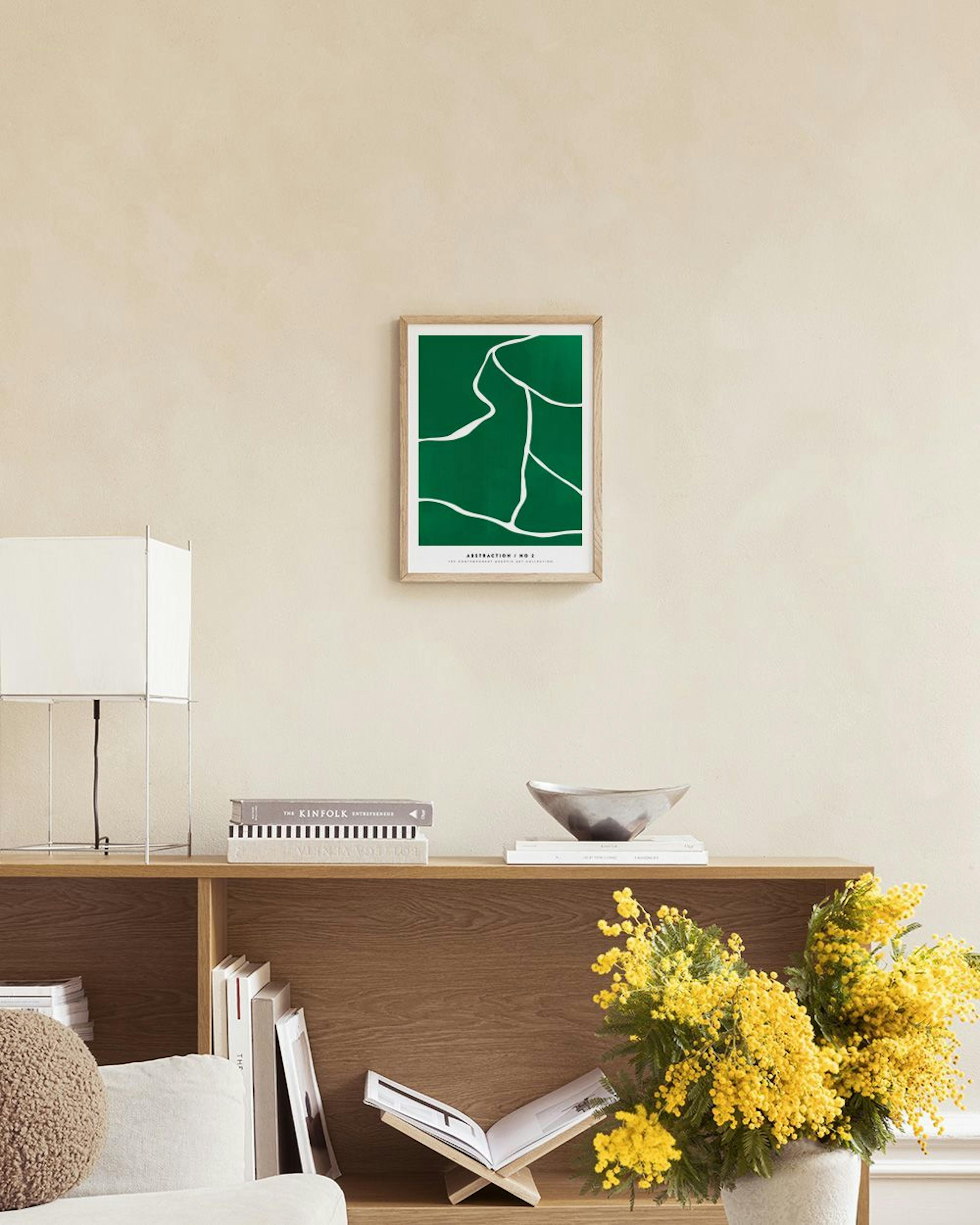 A print with green and white organic lines, hanging above a green velvet ottoman and a black round table.