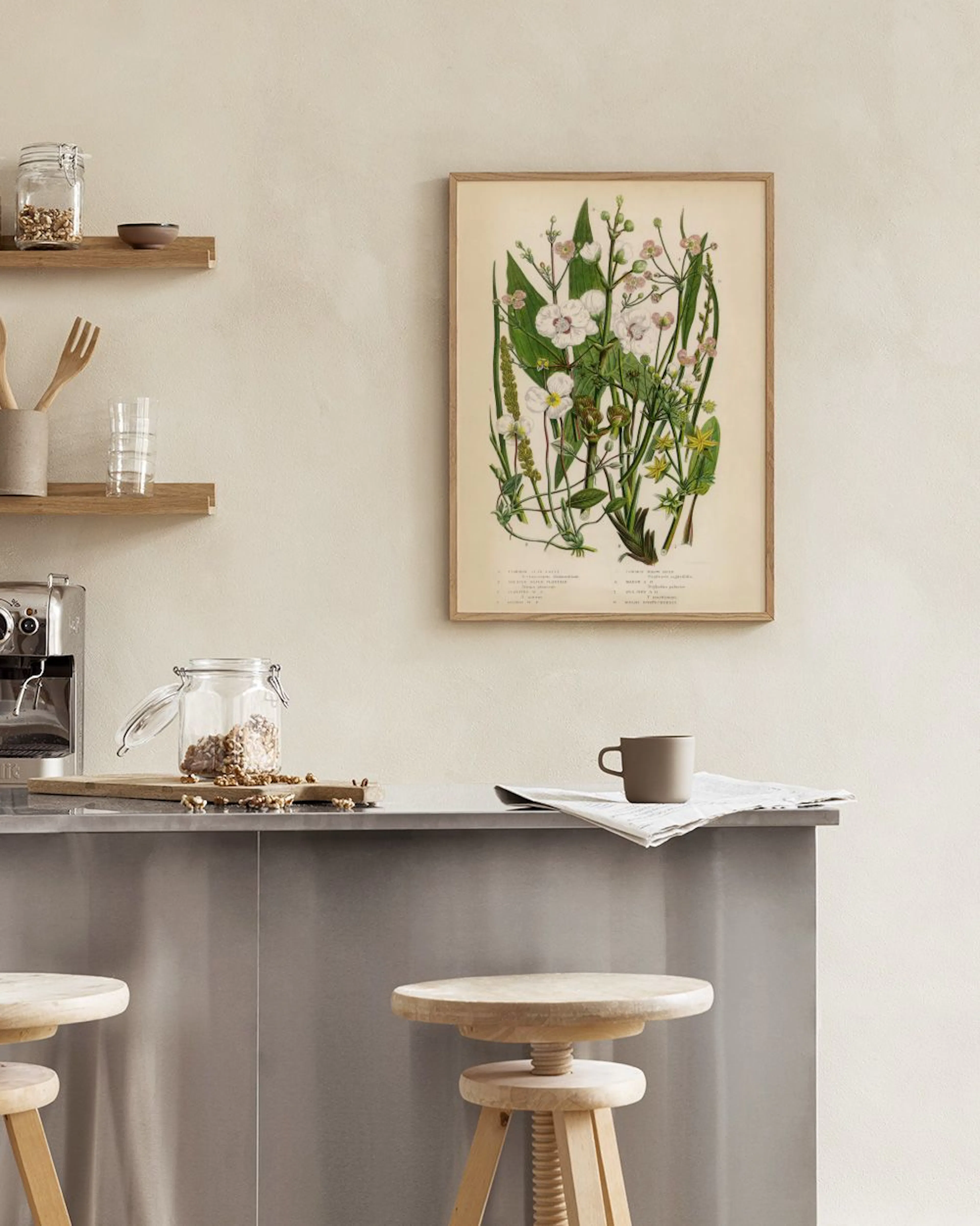 A botanical art print of white and yellow wildflowers on a light background, hanging above a wooden bench with a plant and decor