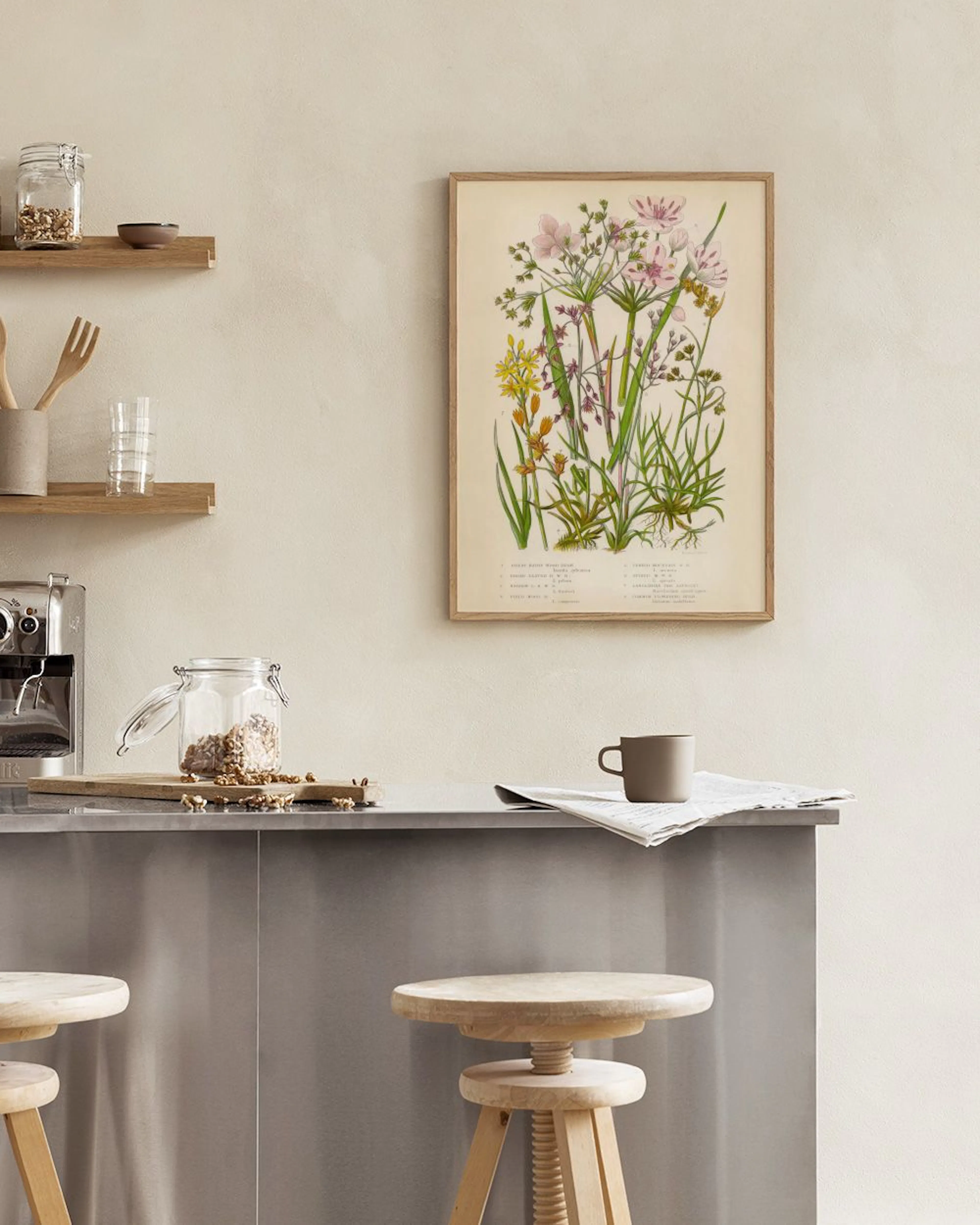 Botanische poster met roze en gele bloemen, hangend aan een witte muur in een lichte kamer.