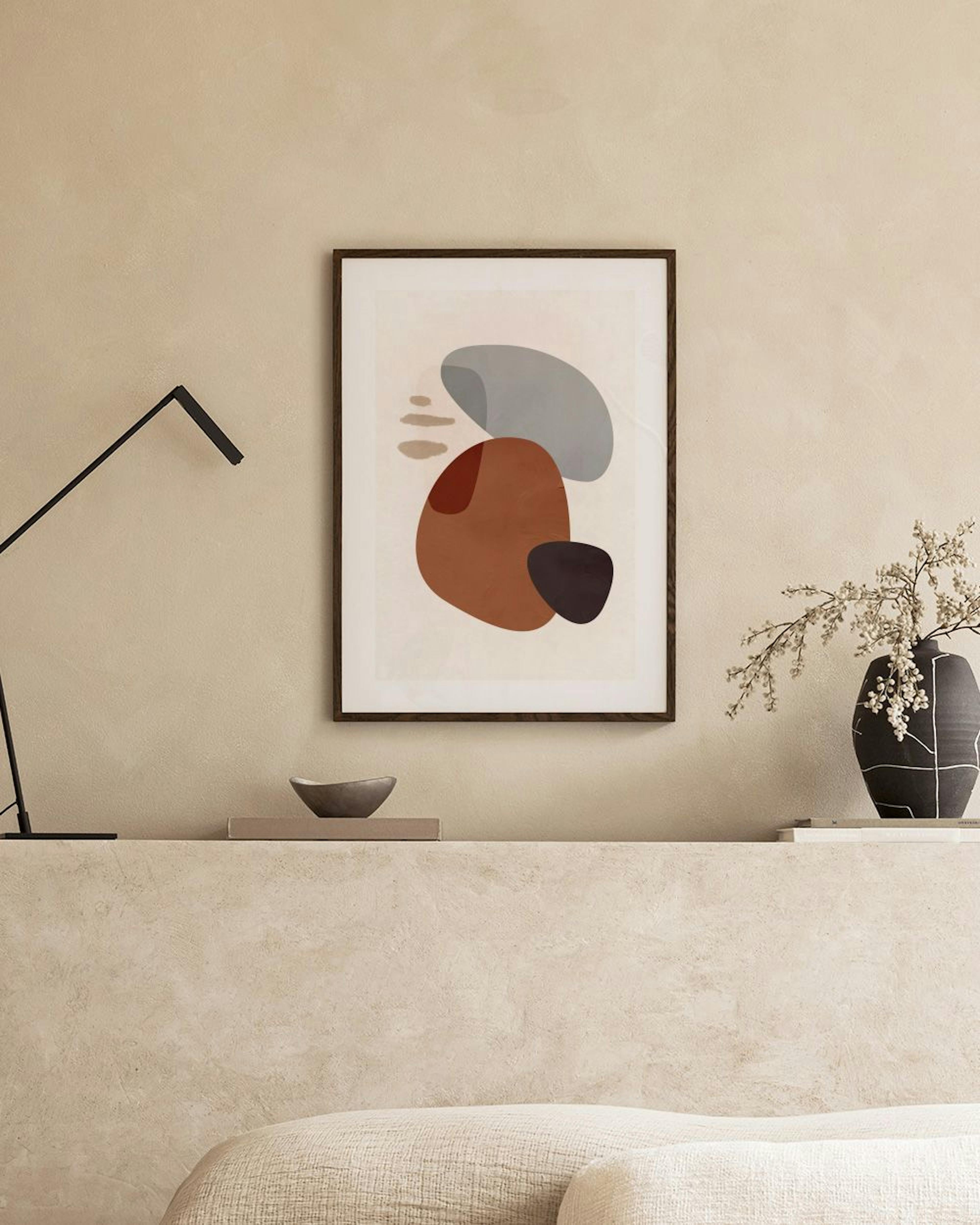 Affiche avec des formes organiques rouille, grises et noires sur fond clair, suspendue dans un salon moderne.