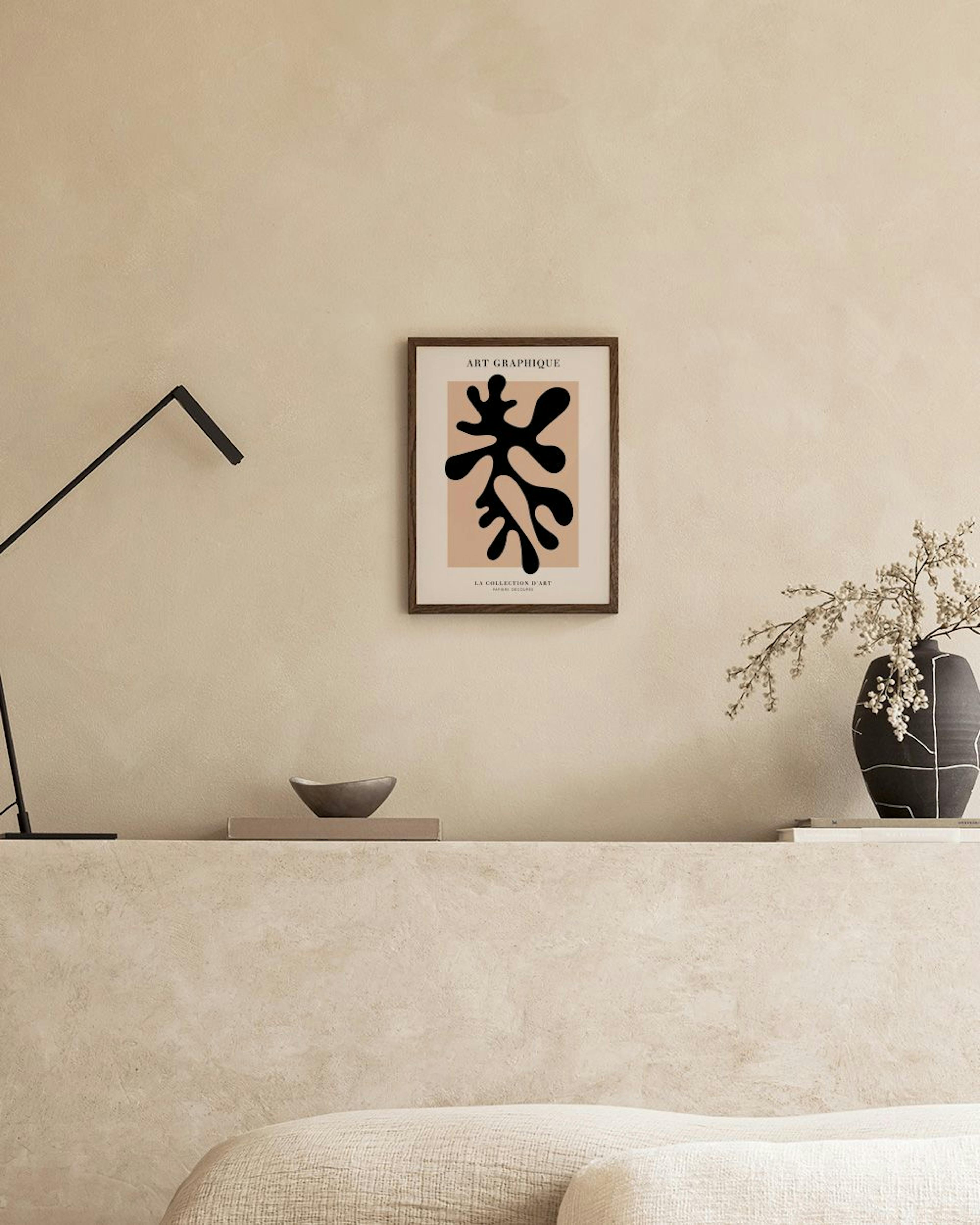 A poster with a black organic shape on a beige background, displayed on a grey console table with decorative objects and a white
