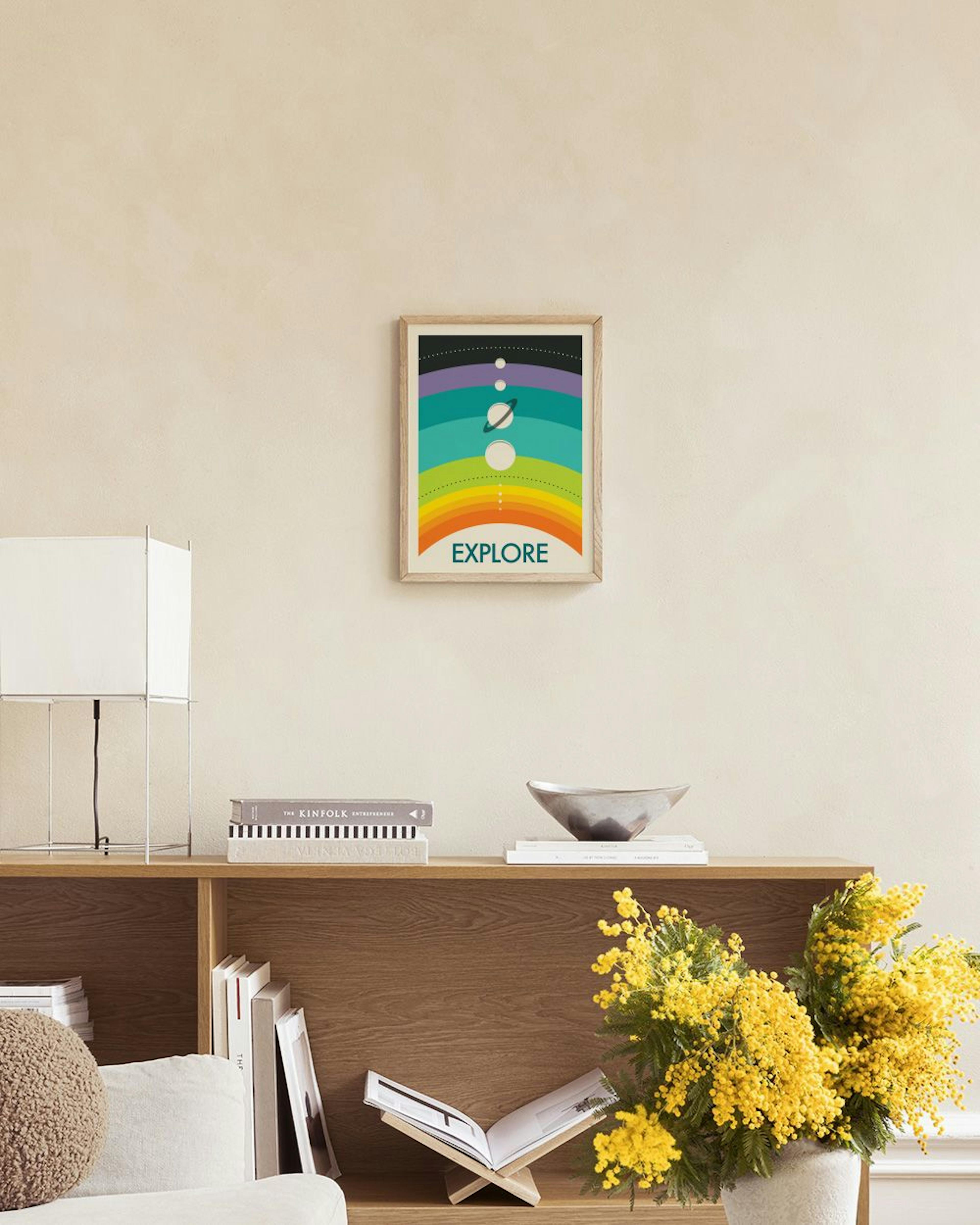 Plakat Explore” z kolorowymi pasami, słońcem i planetami, wiszący nad marmurowym stolikiem z białymi wazonami.