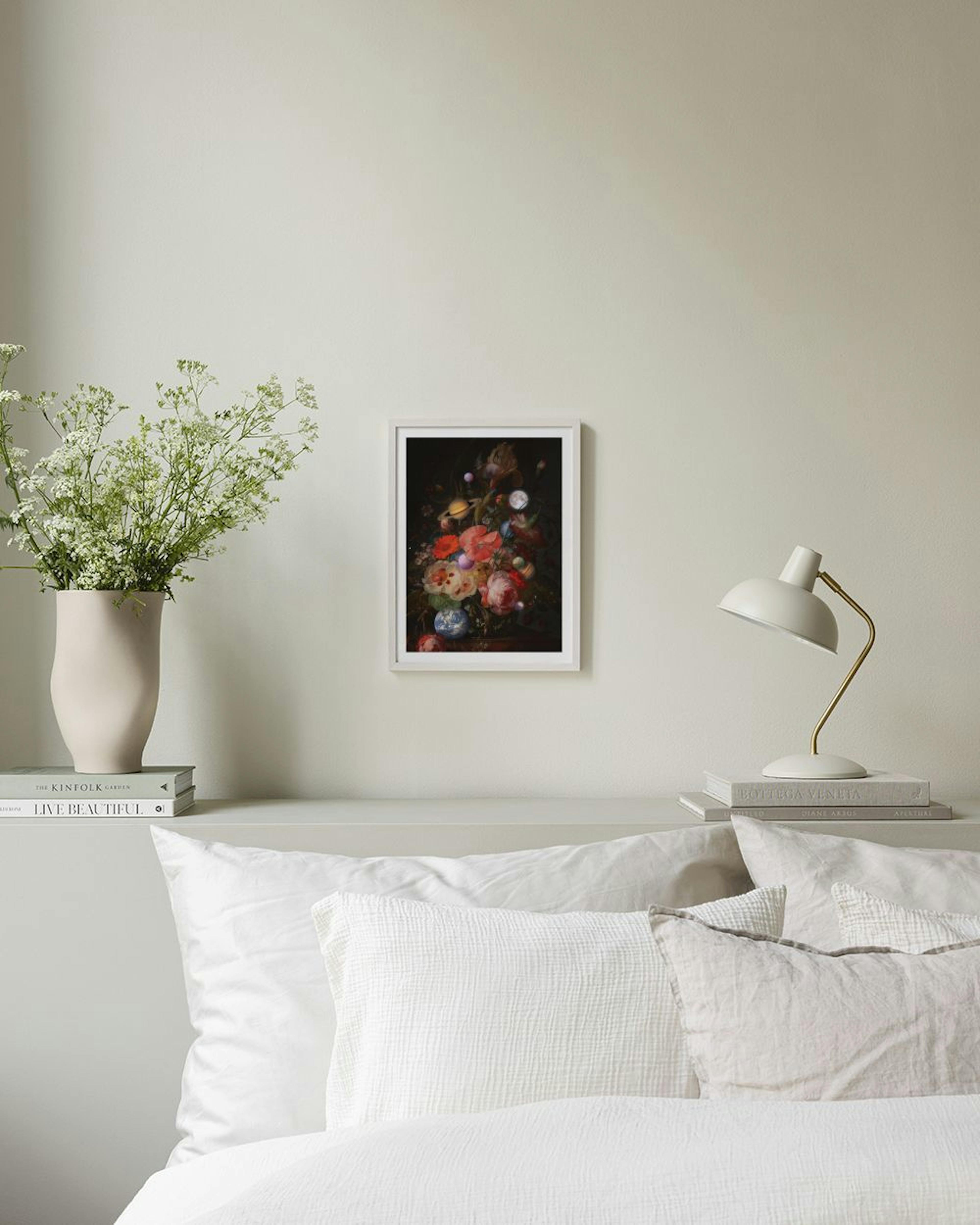 Póster de un arreglo floral con planetas y lunas, colgado sobre un estante negro con libros y objetos decorativos.