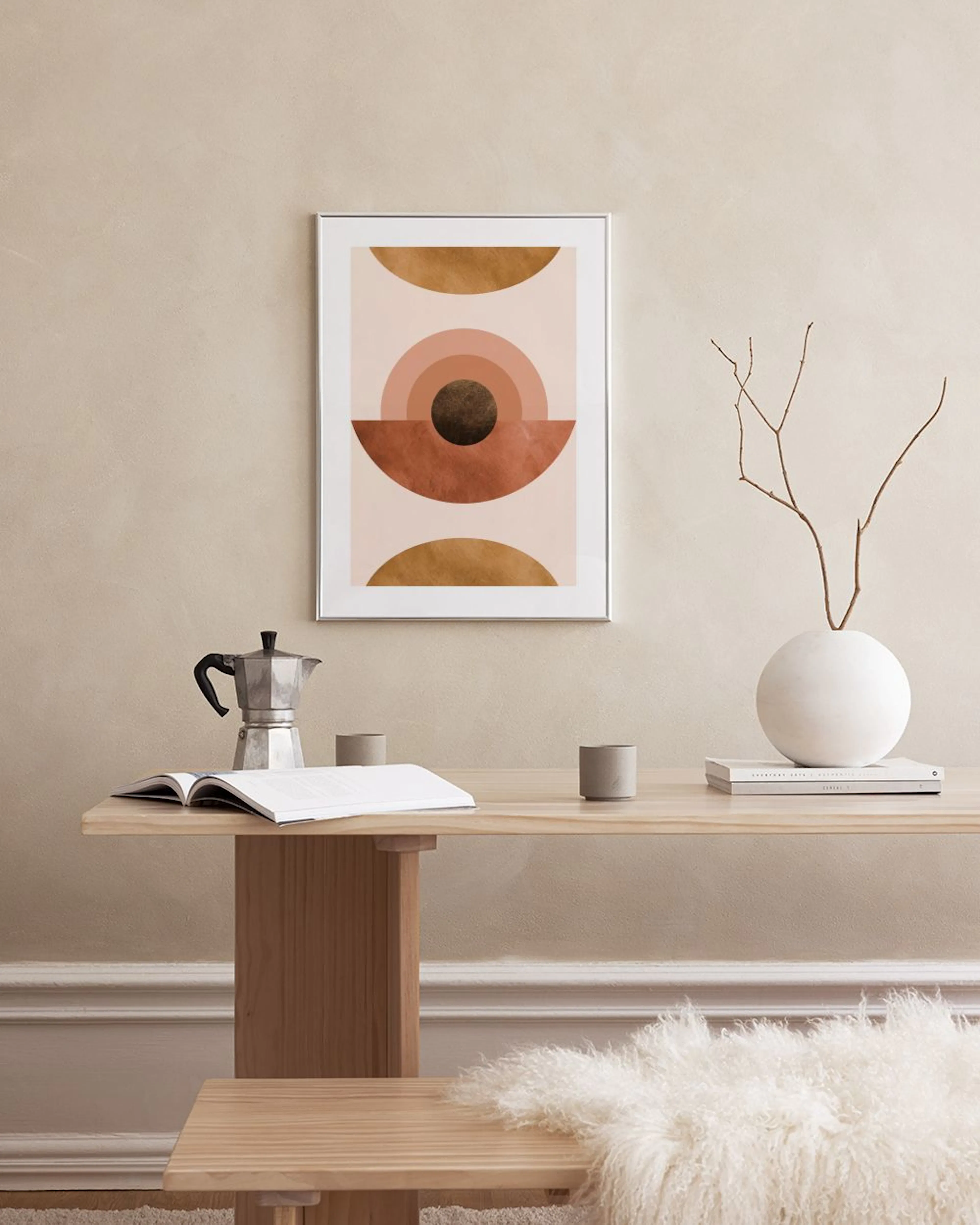 Geometric print with gold, brown, and blush semicircles and circles, hanging in a minimalist living room.
