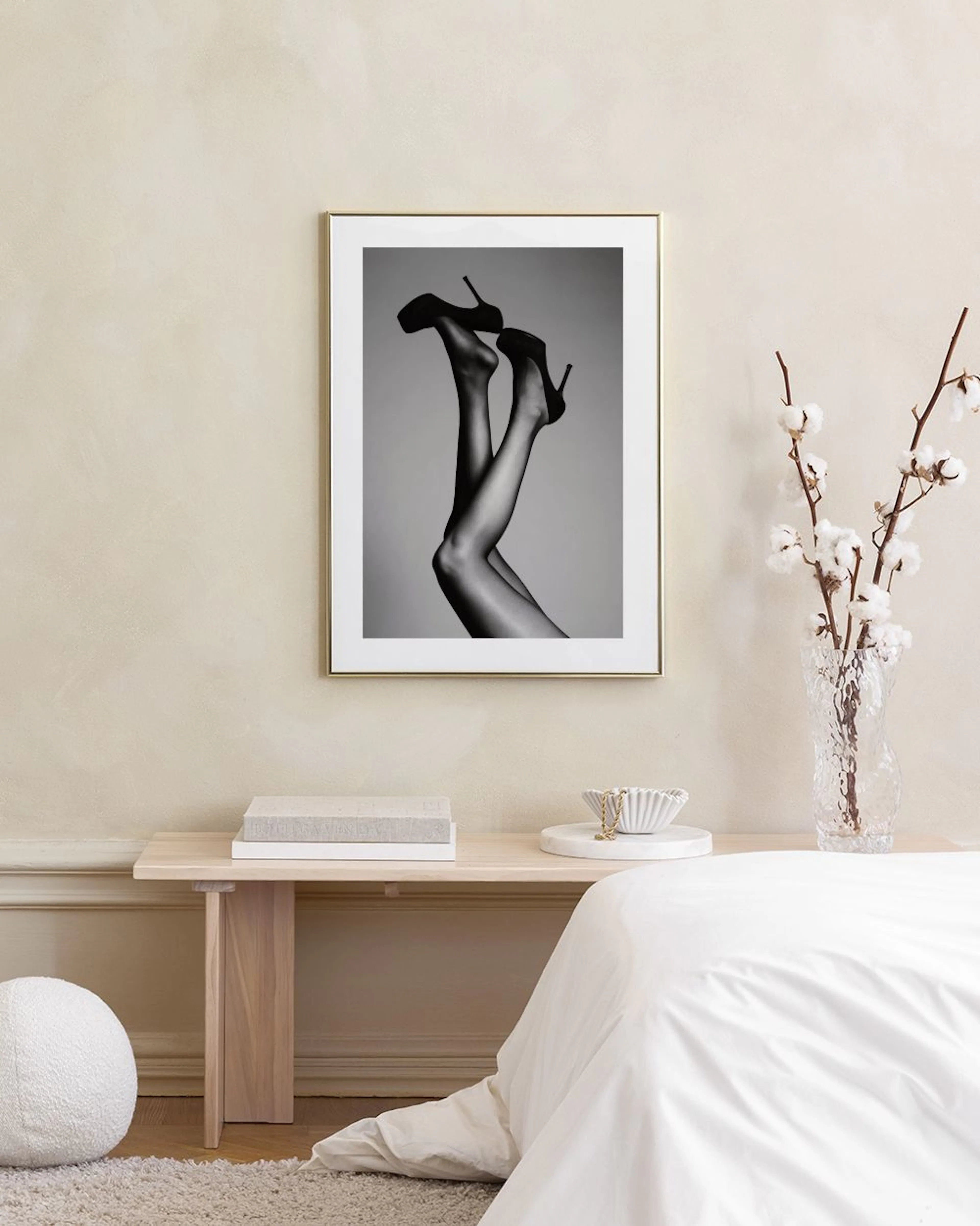 Schwarz-weiß Poster mit Beinen in Strumpfhosen und High Heels, hängend über einem Sideboard mit Büchern und Dekoration.