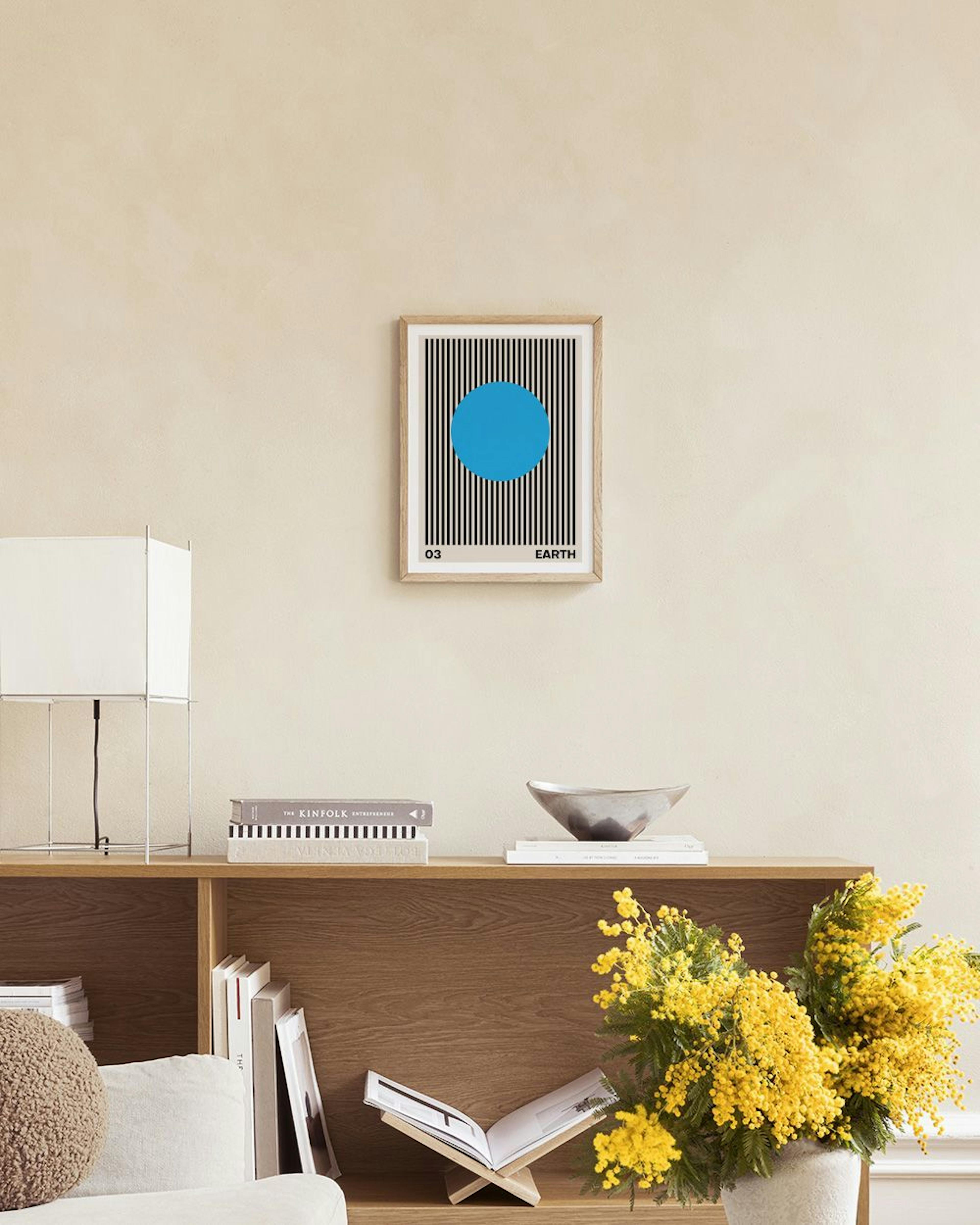 Poster Earth mit blauem Kreis und schwarzen Streifen auf beigem Hintergrund, auf einem grauen Regal.