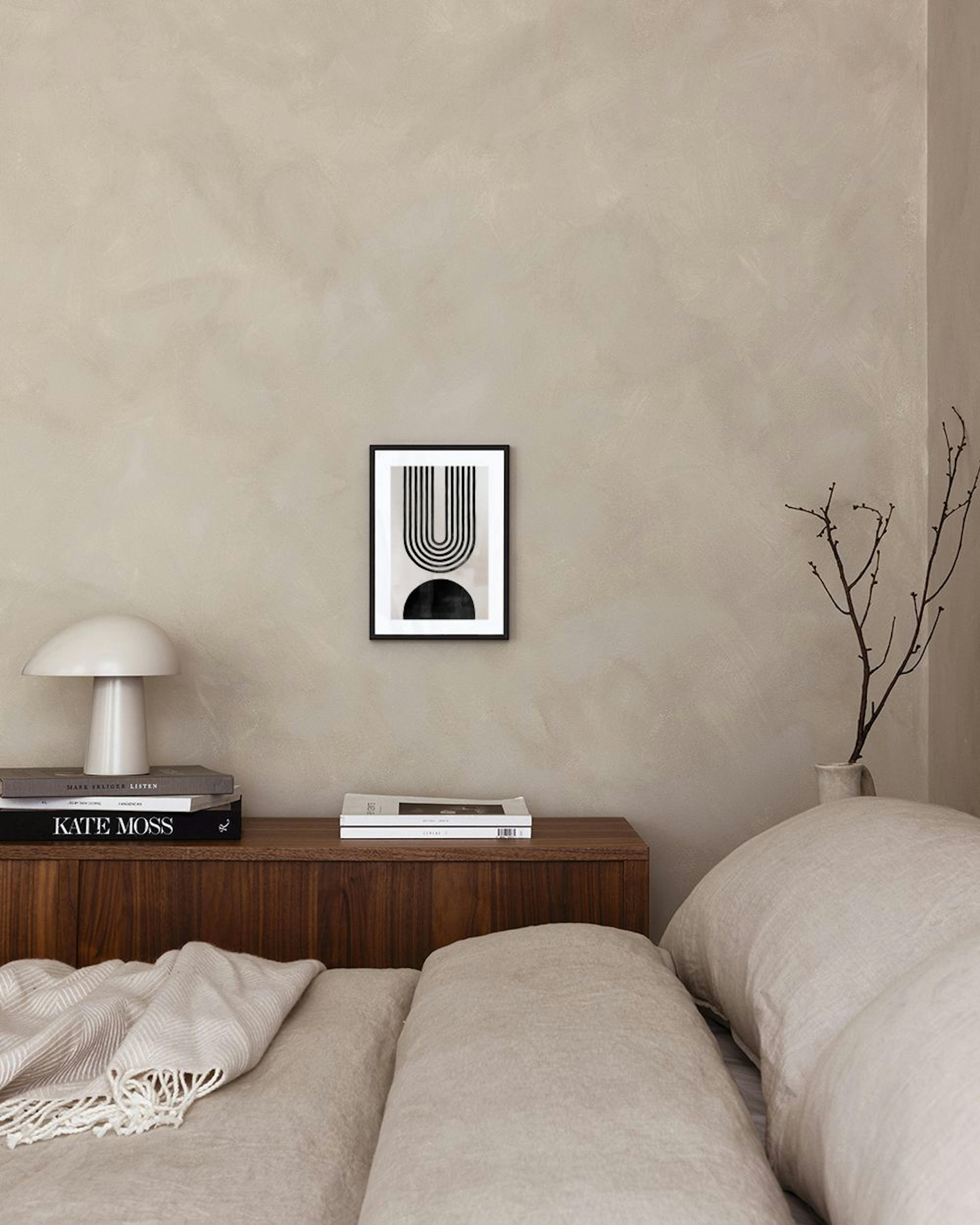 Poster mit schwarzen Halbkreisen und Linien, über einer weißen Kommode mit Lampe und Vase.