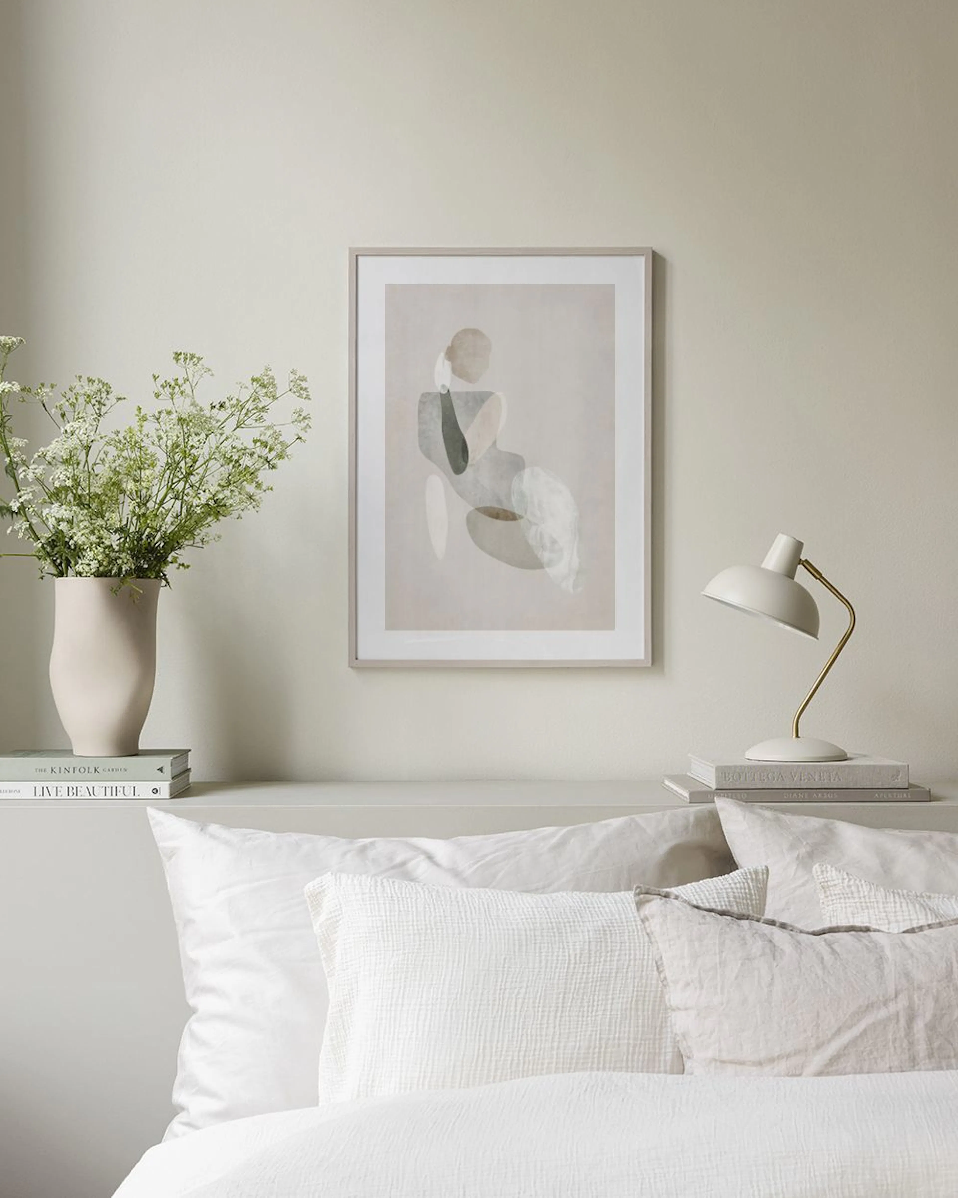 Plakat: abstrakcyjna postać ludzka z organicznymi kształtami w odcieniach beżu i szarości, w jasnym, minimalistycznym pokoju.