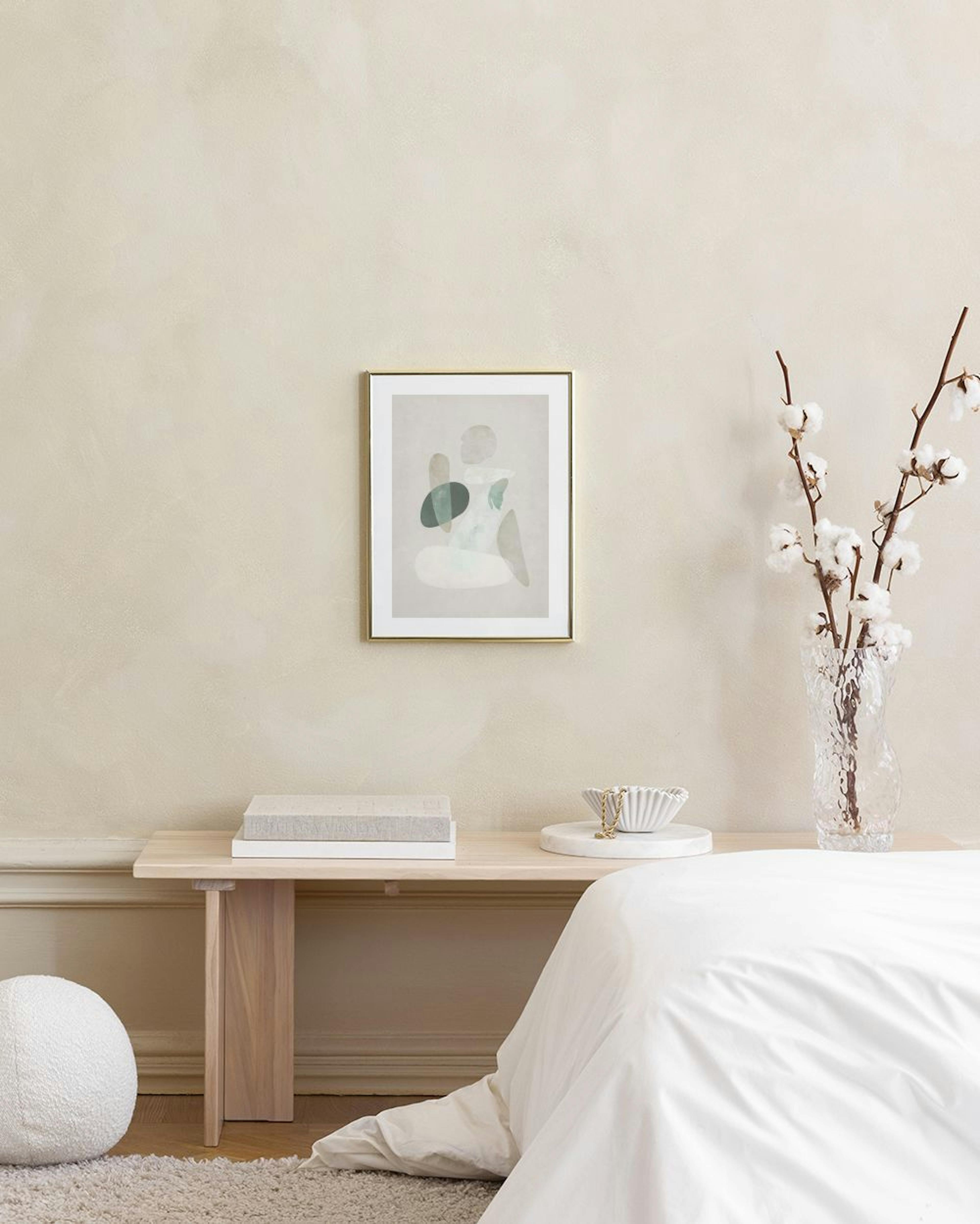 Poster med abstrakta former i jordnära färger som grönt, beige och vitt, hängande i ett rum med en grön sammetsfåtölj och en vas