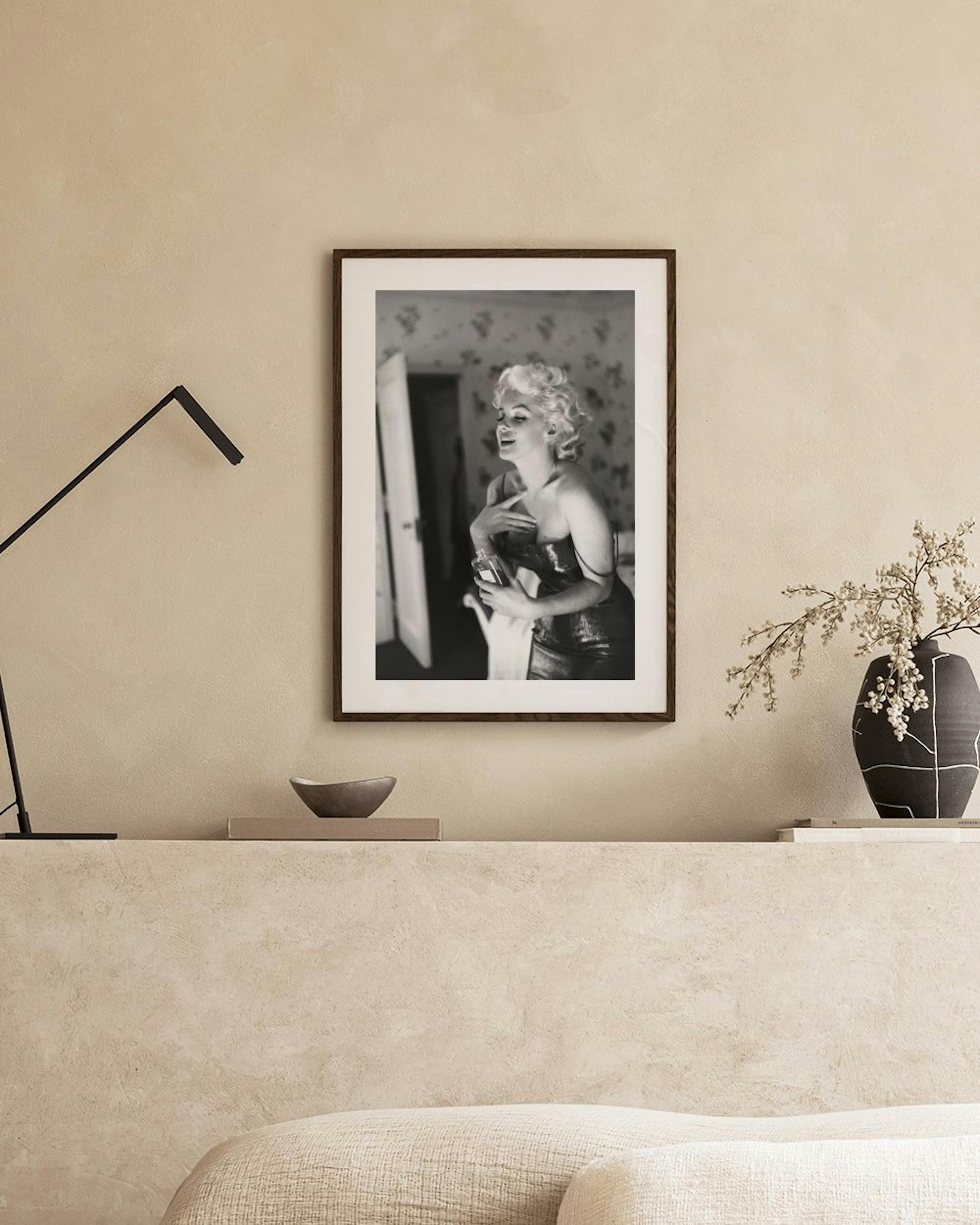 Poster in bianco e nero di Marilyn Monroe che si guarda allo specchio, appeso sopra una credenza bianca in un soggiorno moderno.