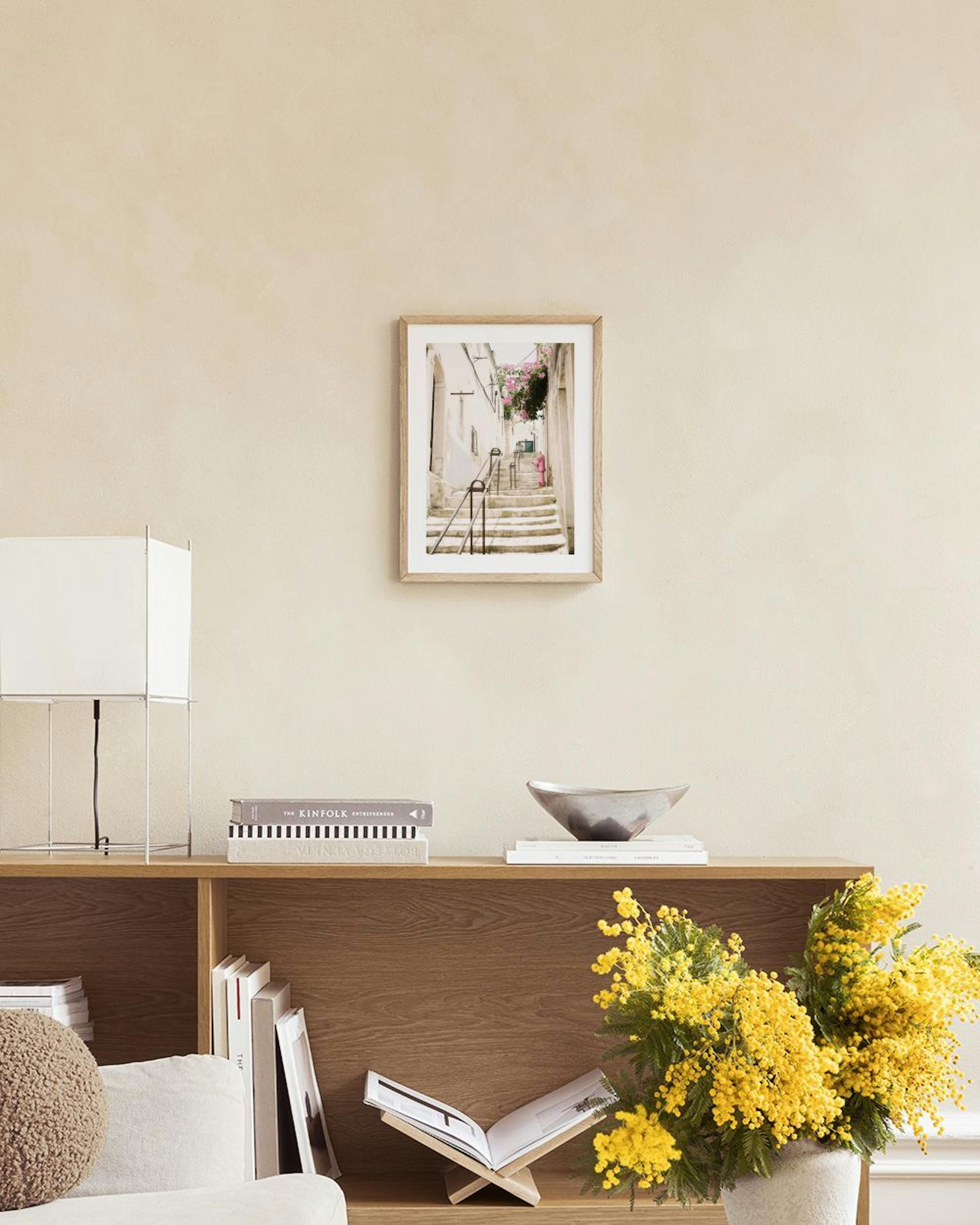 Parede de quadros com posters de Veneza, uma escadaria e um edifício clássico, numa sala de estar minimalista.