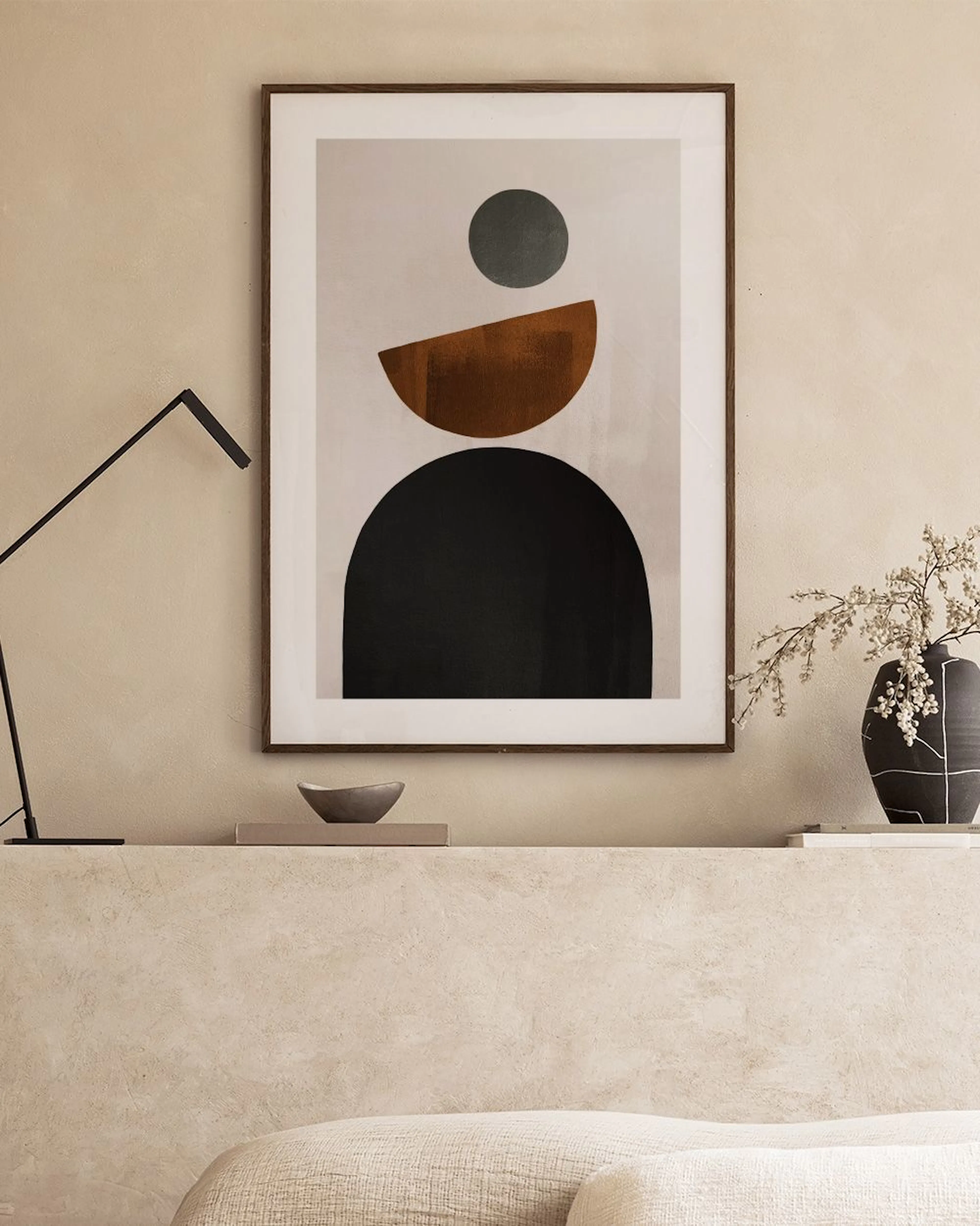 Abstract print with black, brown, and grey geometric shapes on a light background, in a modern living room.