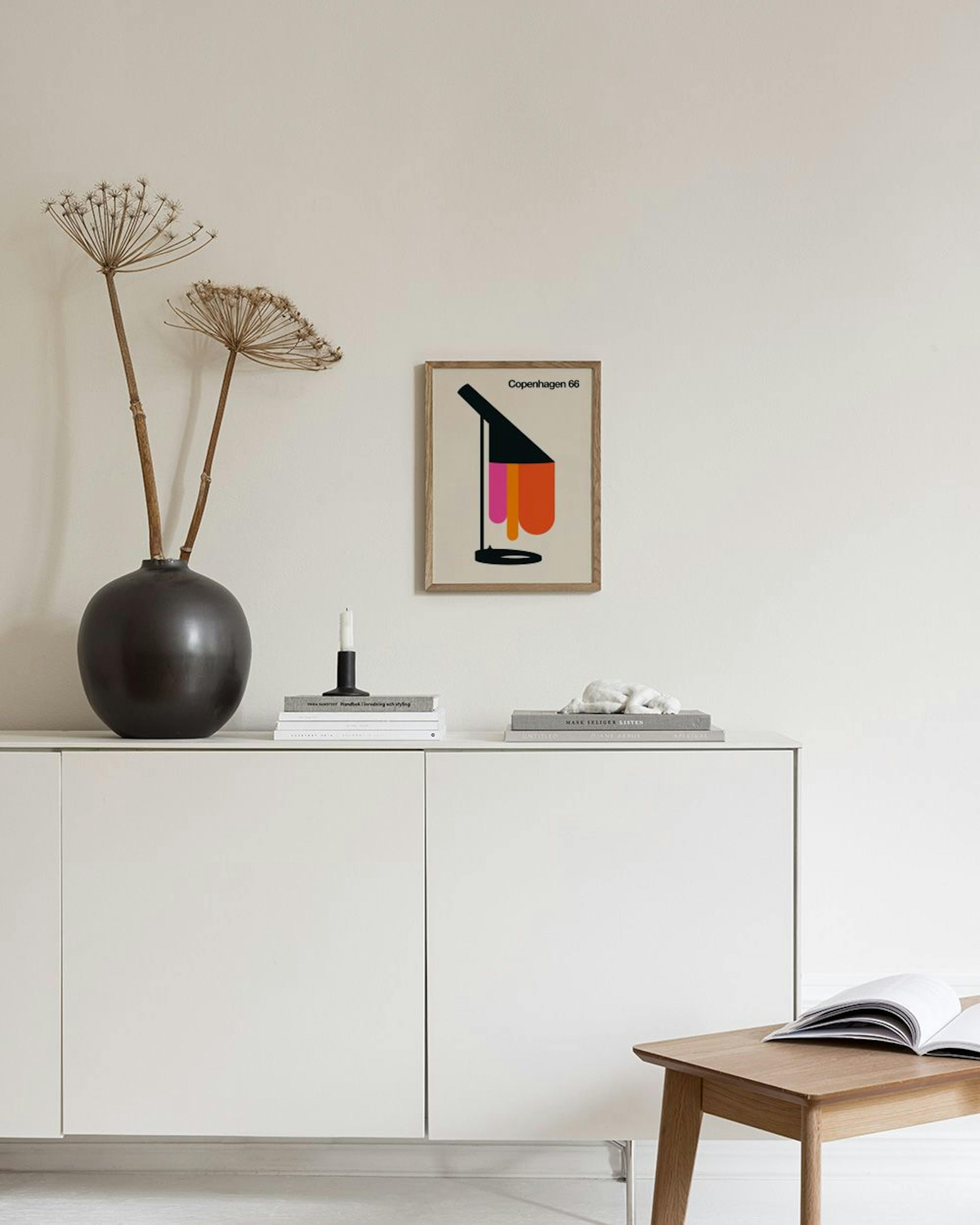 Plakat med sort lampeskygge, pink og orange former, og teksten Copenhagen 66, hængende over en sort skammel med bøger.