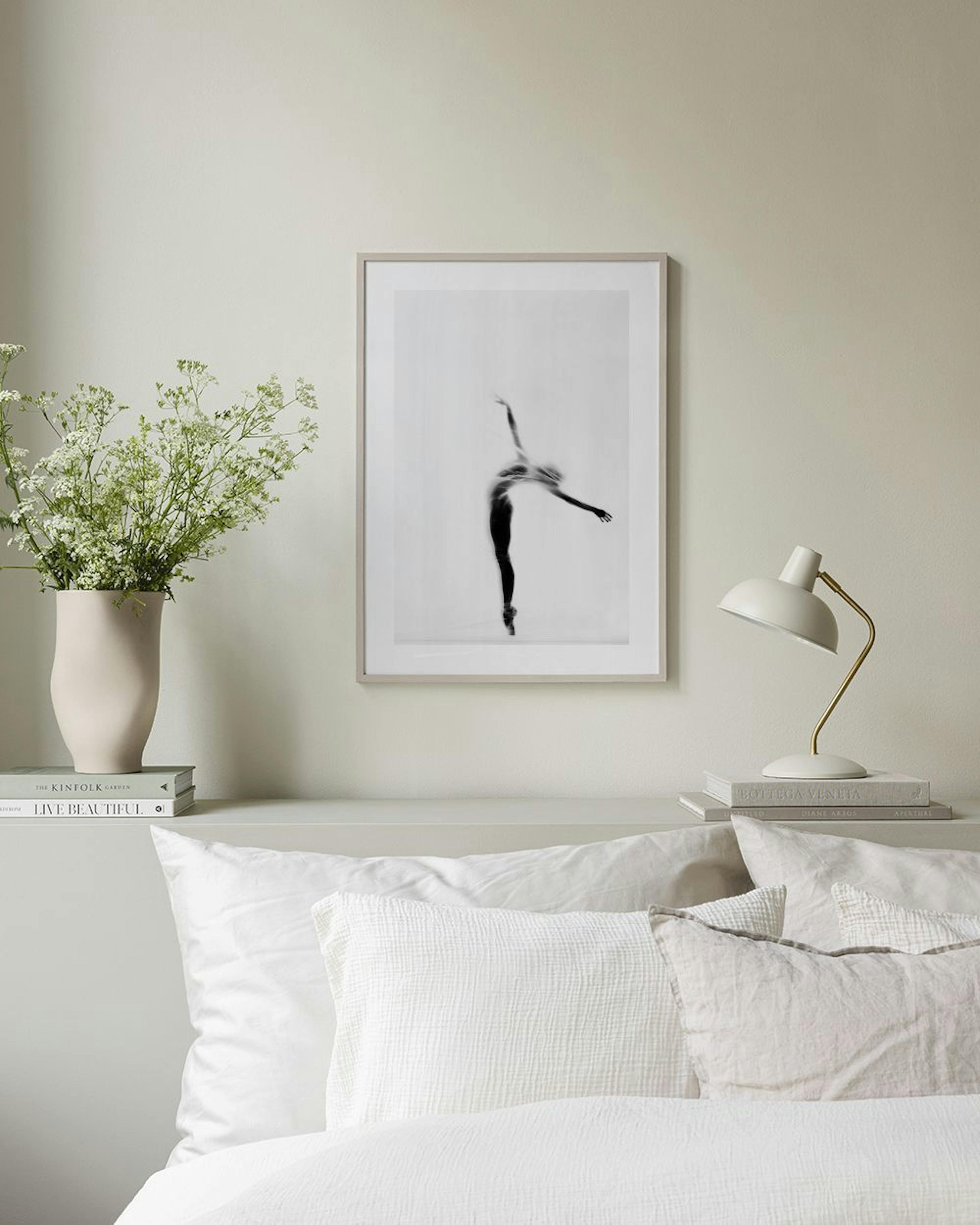 A black and white print of a ballerina en pointe, hanging above a black console table in a minimalist room.