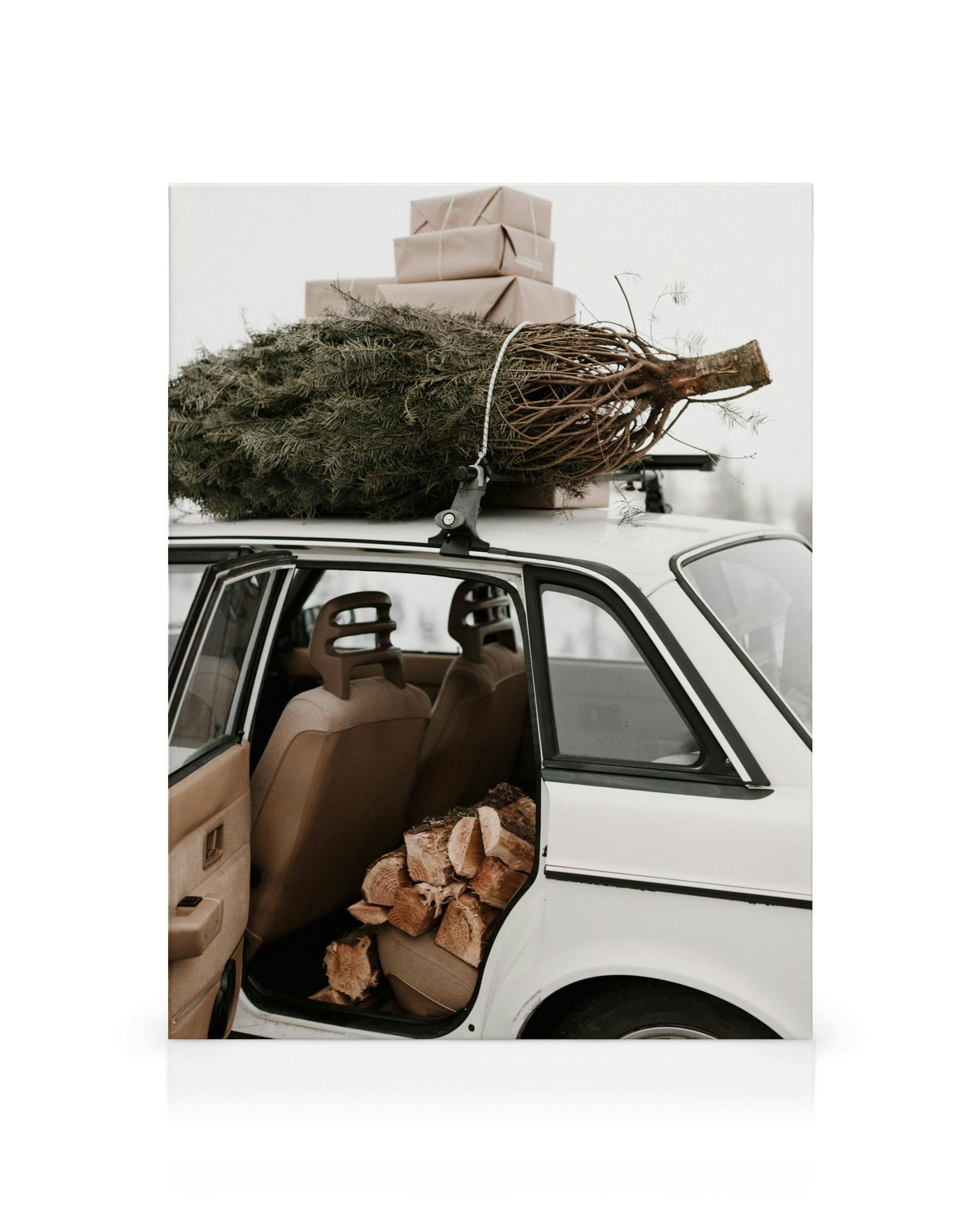 Weißer Oldtimer mit Weihnachtsbaum und Geschenken auf dem Dach, Holzscheite im Innenraum, Wintermotiv.
