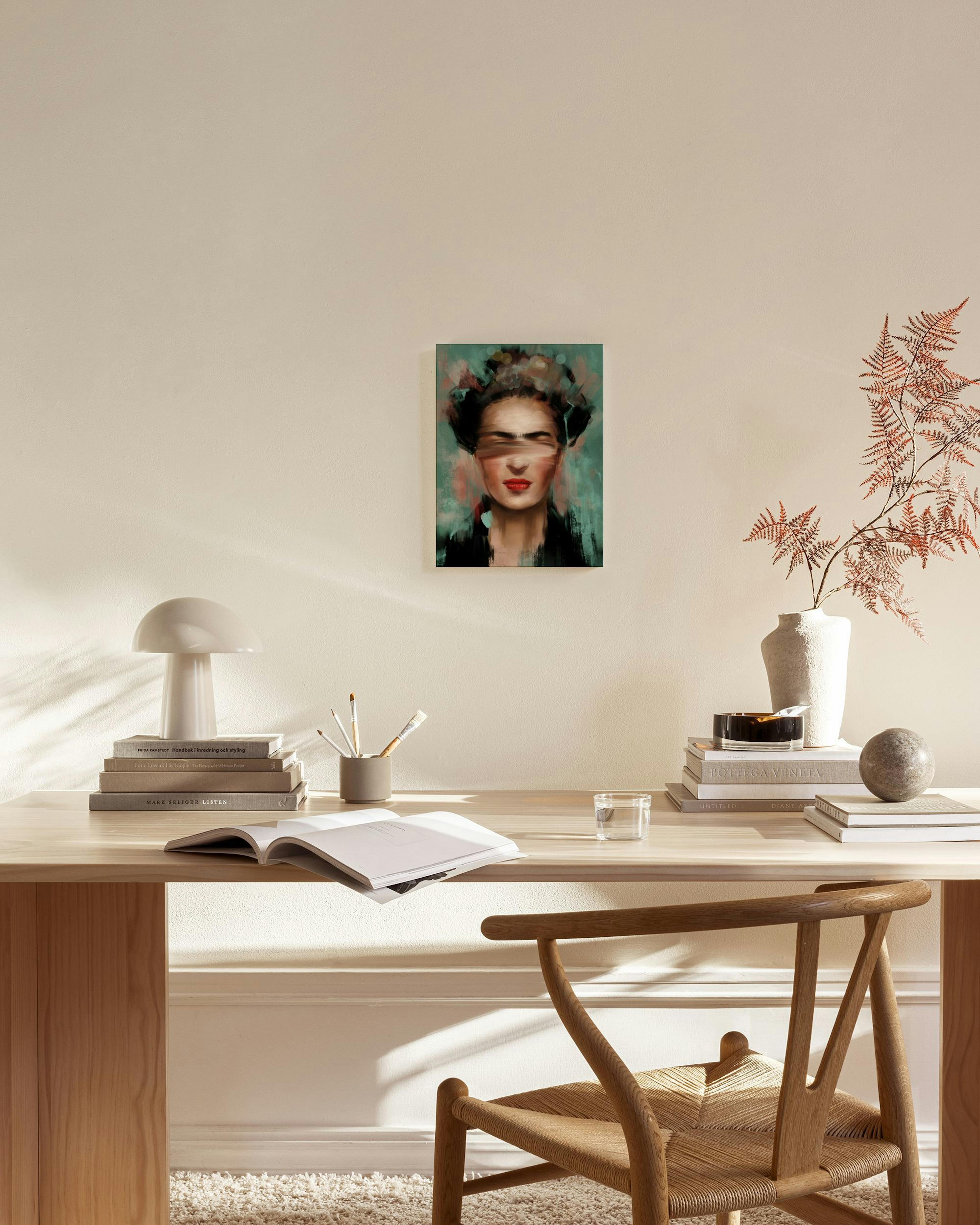 Leinwandbild von Frida Kahlo mit Augenbalken, roten Lippen und bunten Haaren, hängend über einem Sideboard.