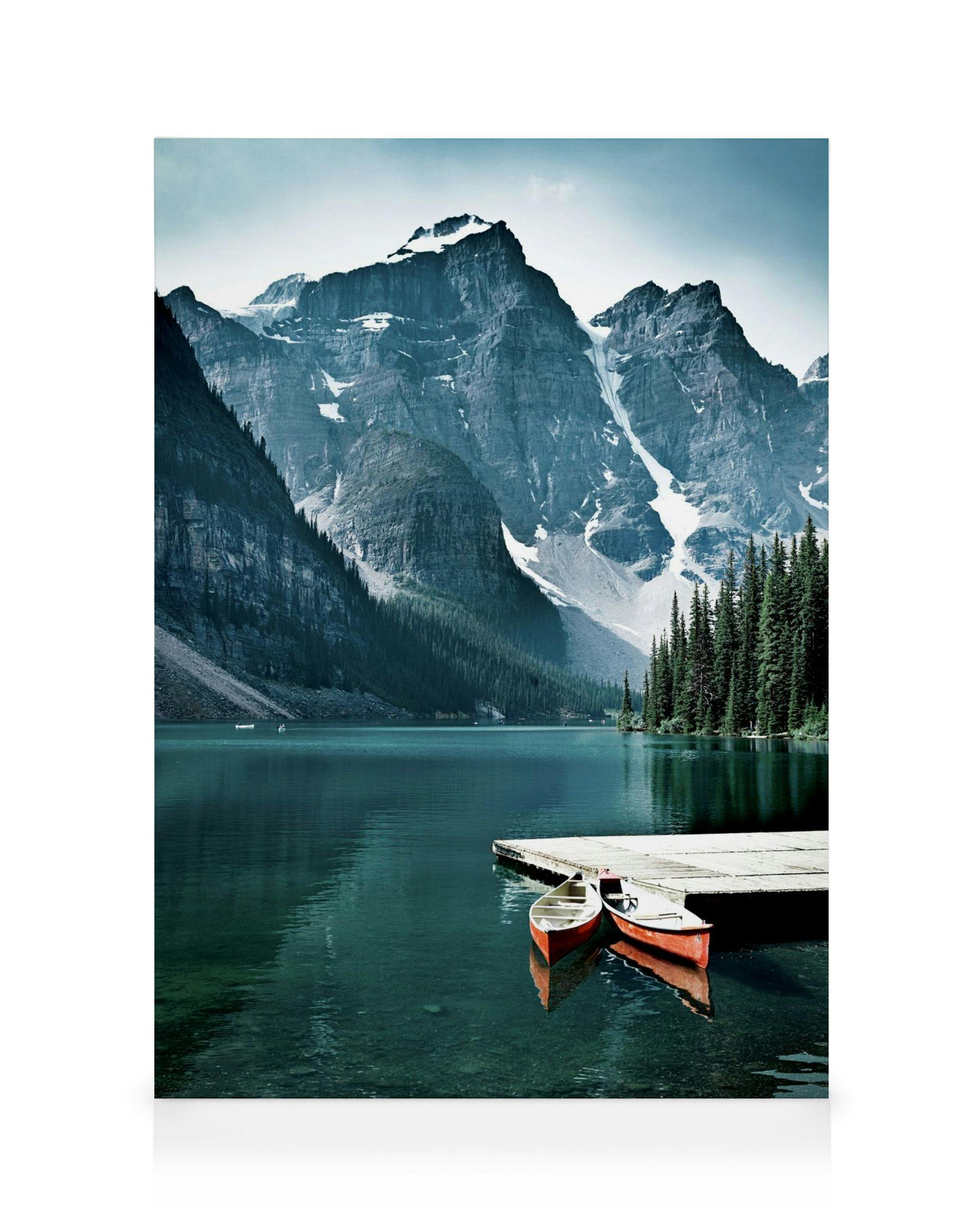 Two red canoes by a pier on a calm lake, surrounded by majestic mountains and a lush forest. Nature landscape art.