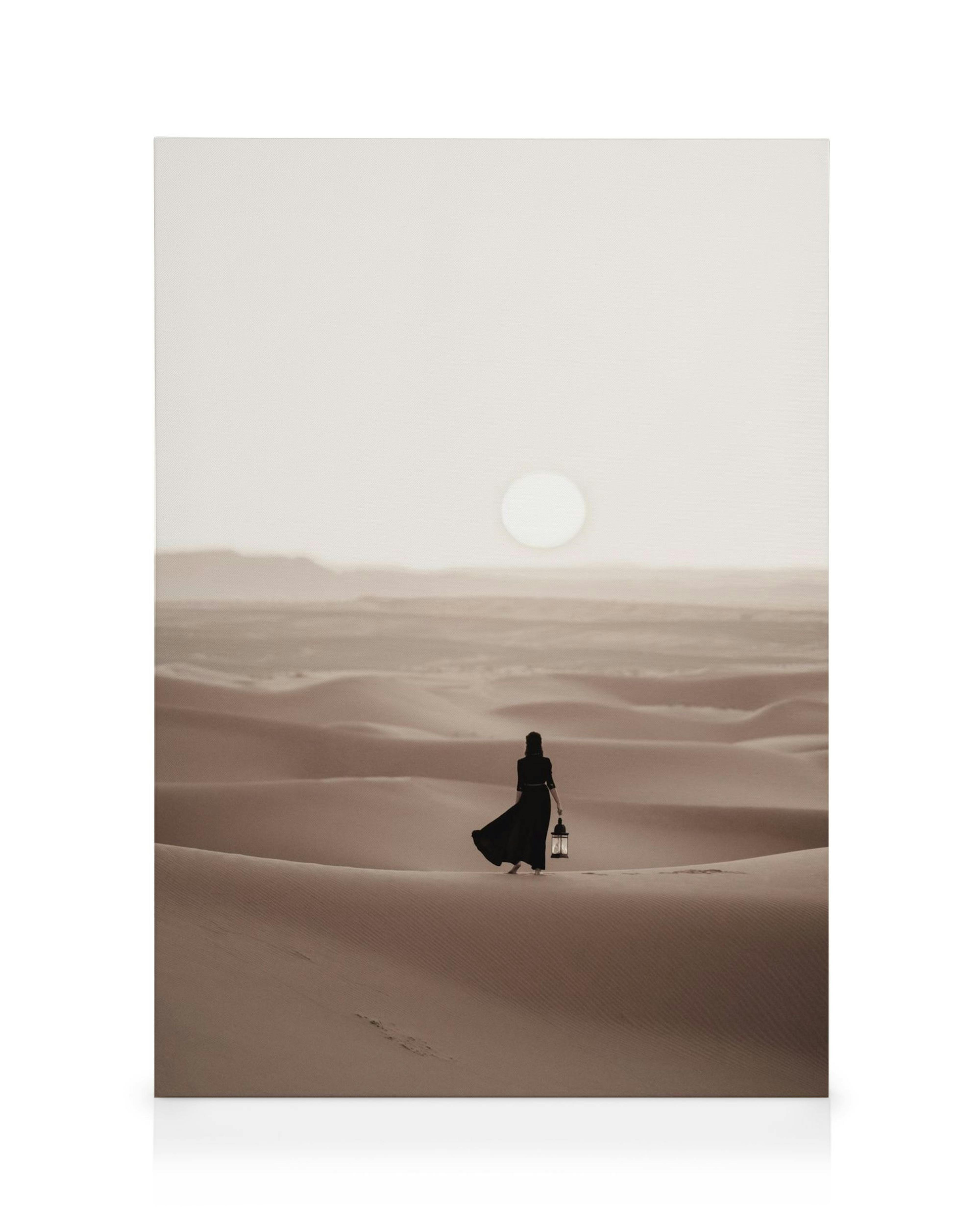 Frau in schwarzem Kleid mit Laterne geht durch eine weite Wüste bei Sonnenuntergang, sepiafarbenes Design.