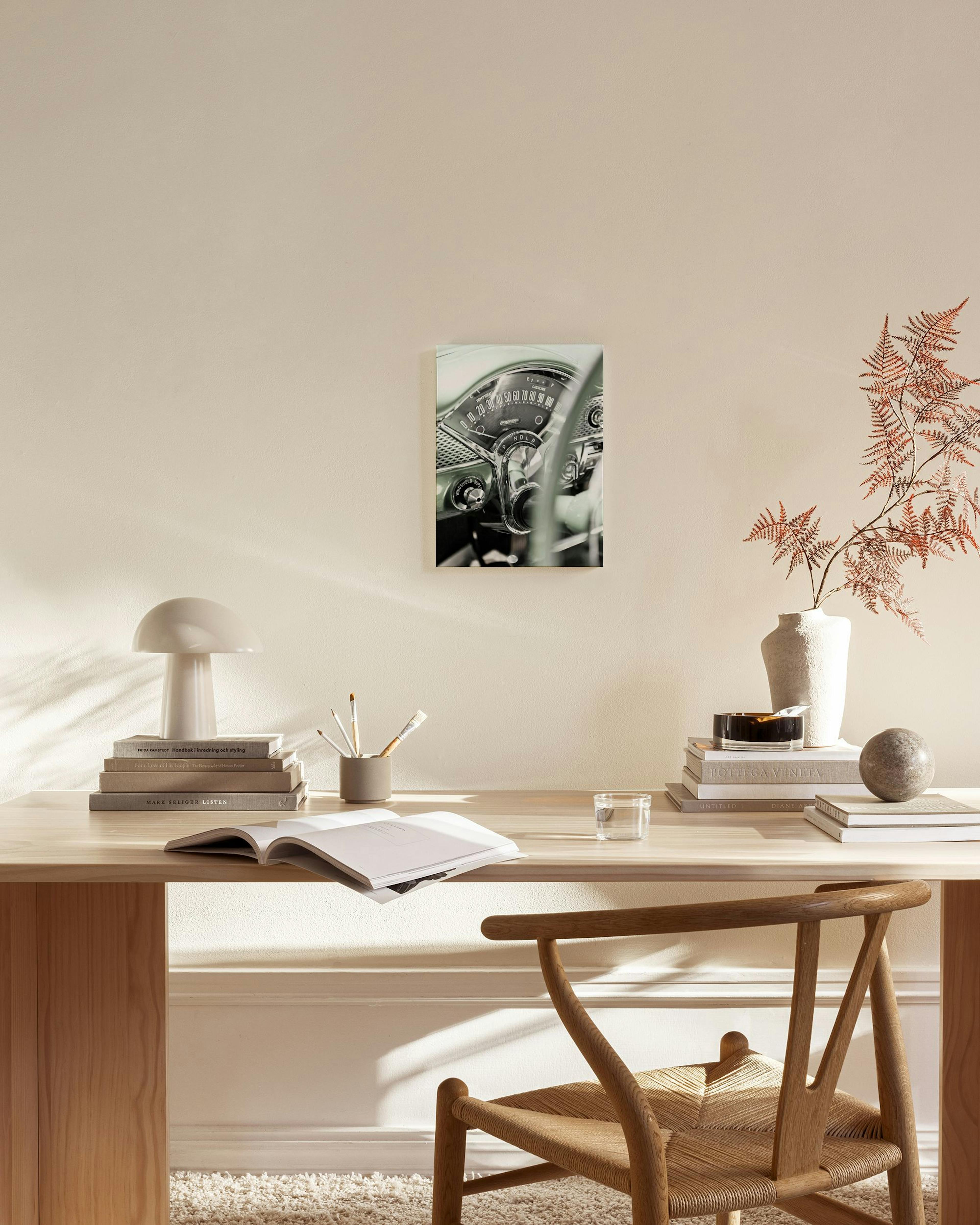 Canvas van een vintage autodashboard in grijsgroen, hangend in een moderne woonkamer met houten meubels.