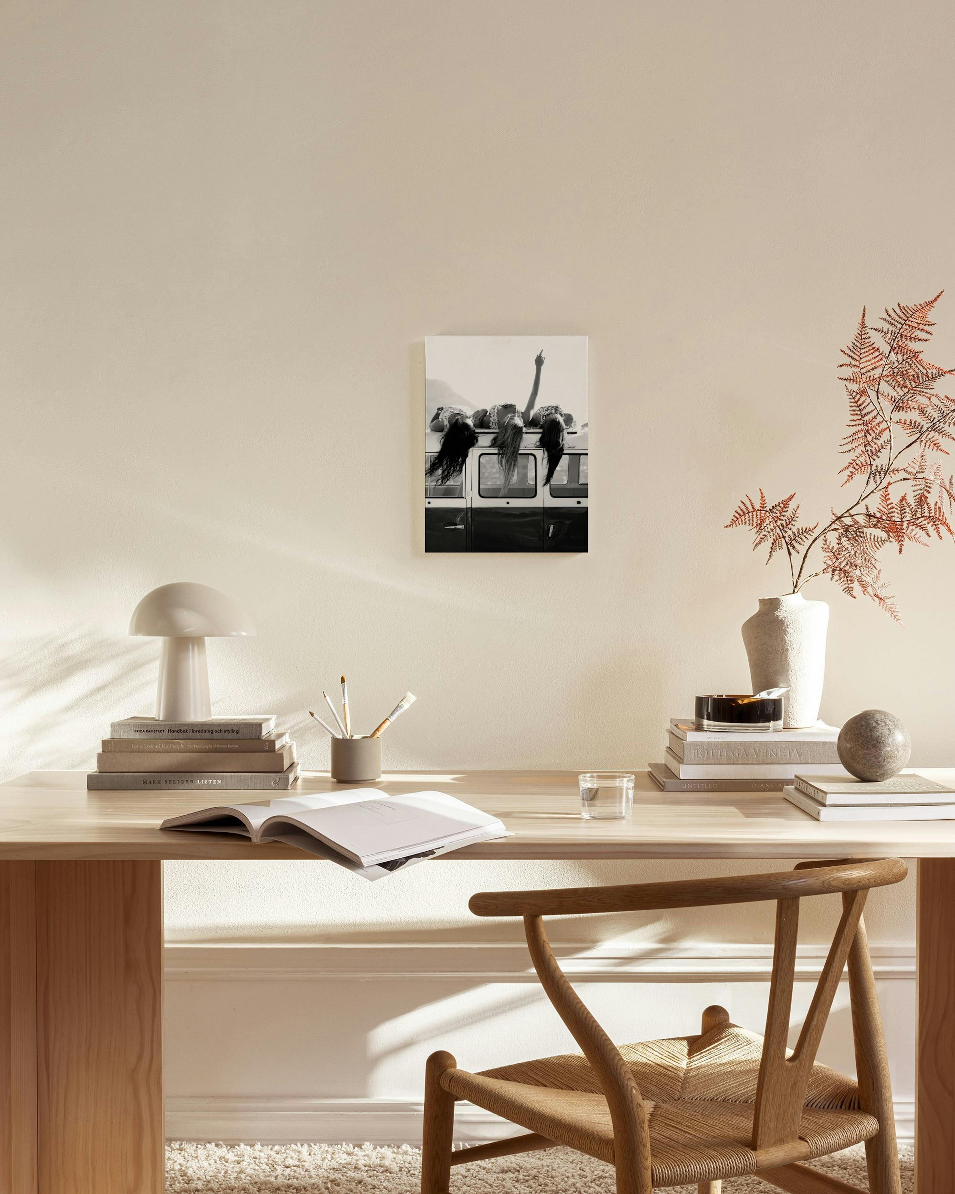 Zwart-wit canvas van meisjes op een busje, met een arm omhoog, hangend in een moderne, lichte woonkamer.