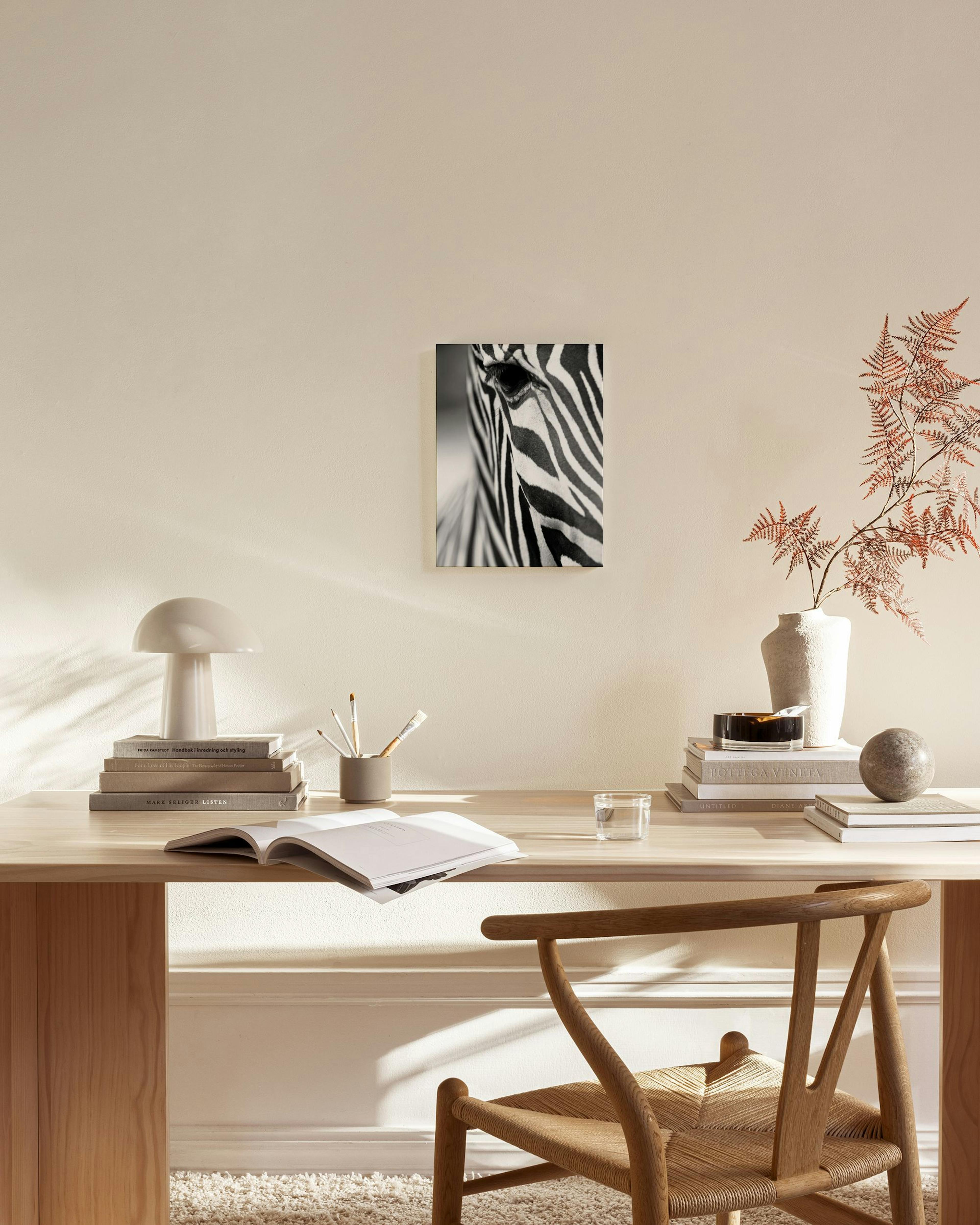 Stampa su tela in bianco e nero con primo piano di occhi e strisce di zebra, appesa in un soggiorno moderno.