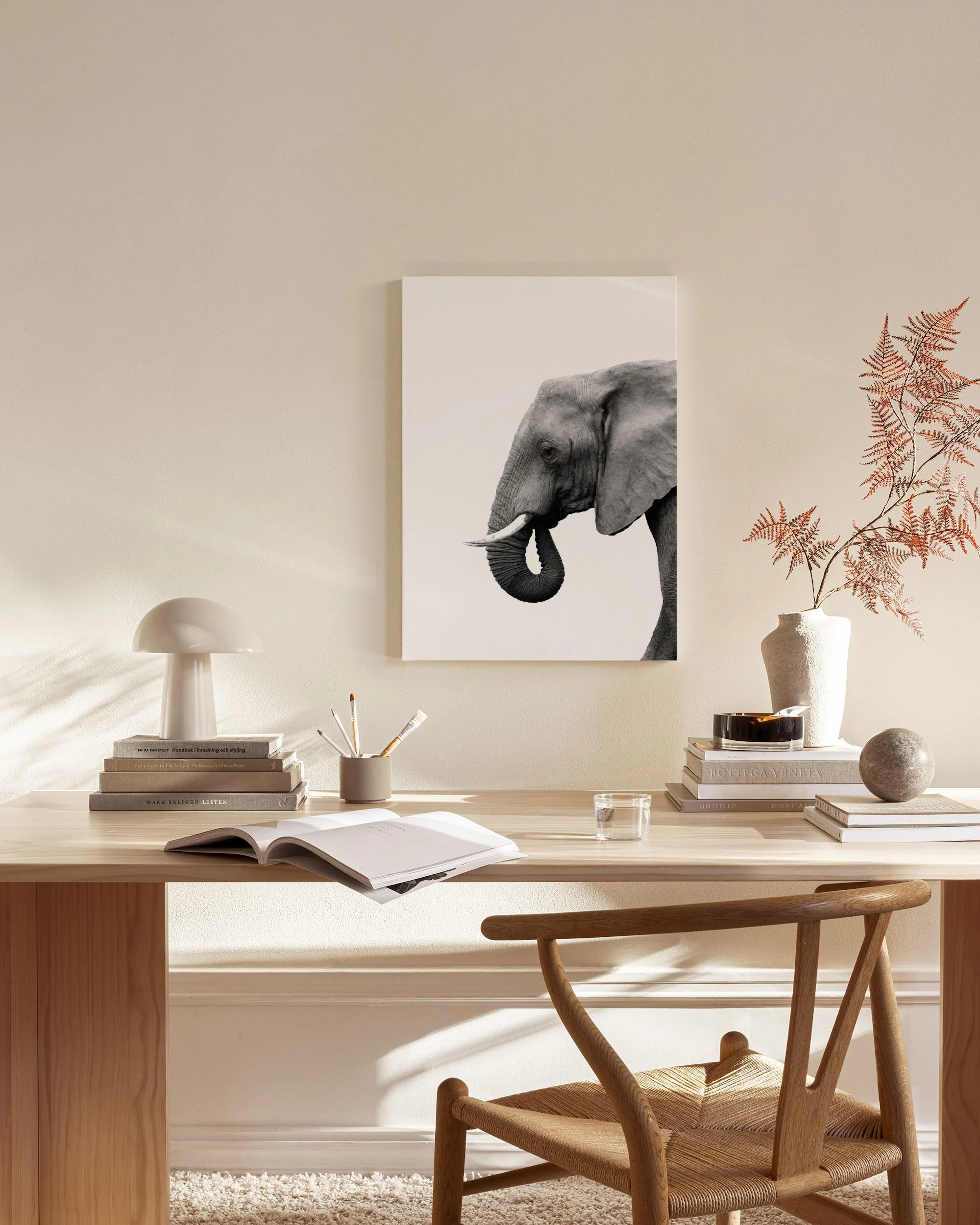 Stampa su tela in bianco e nero di un elefante, esposta in un soggiorno moderno sopra una credenza in legno.