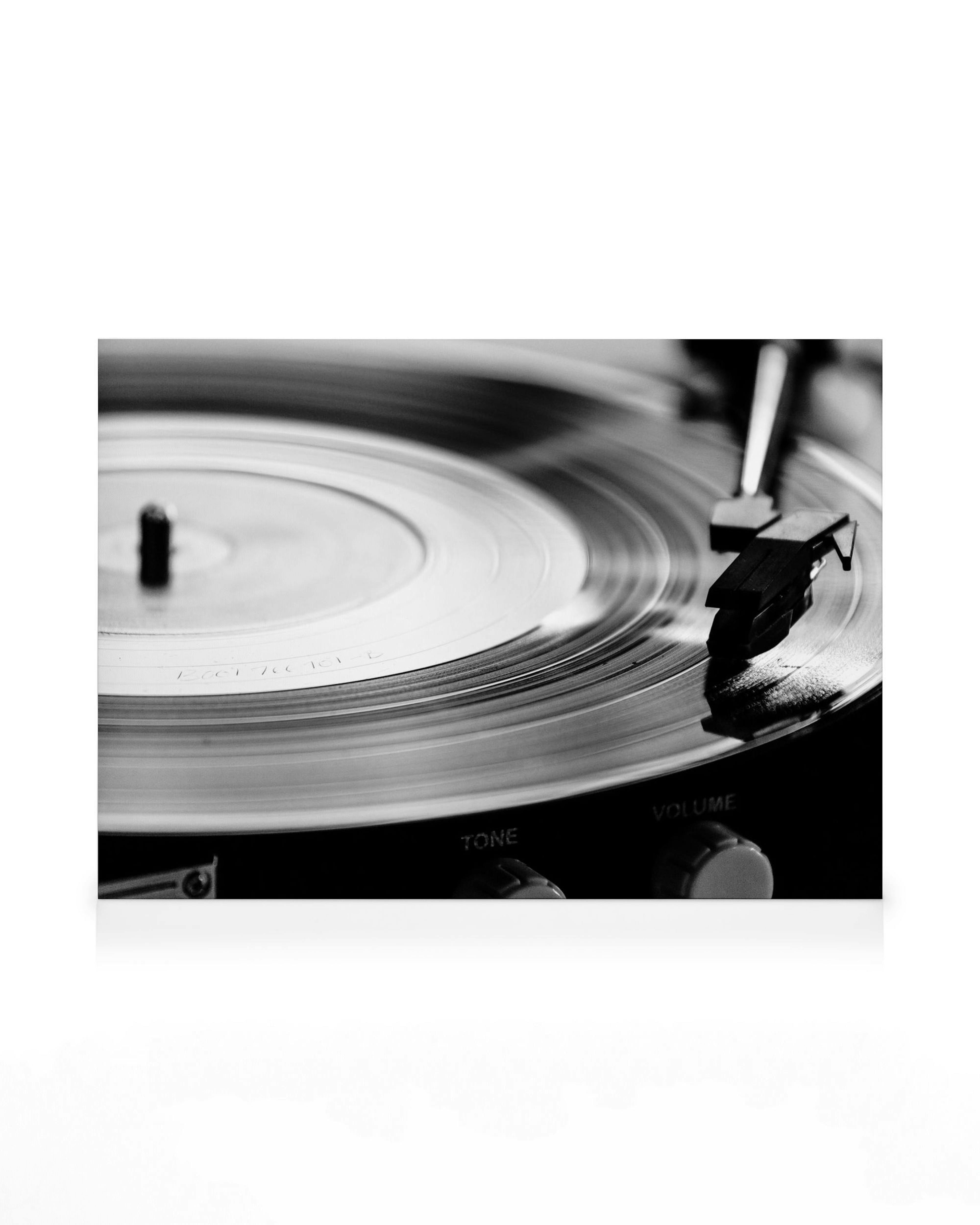 Zwart-wit canvas van een draaiende vinylplaat op een draaitafel, perfecte muurkunst voor muziekliefhebbers.