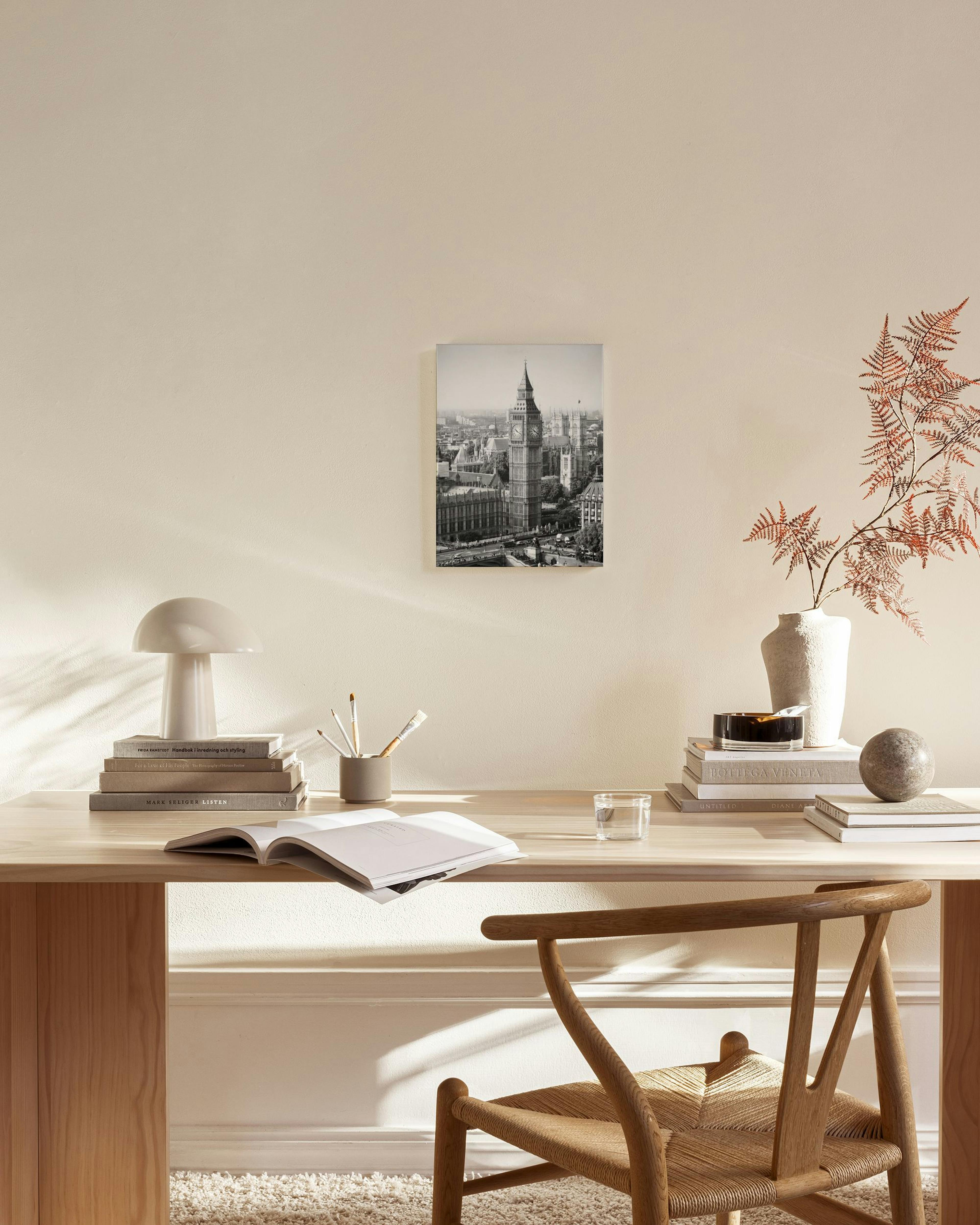 Zwart-wit canvas van de Big Ben en de Londense skyline, hangend in een neutrale woonkamer met houten meubels.