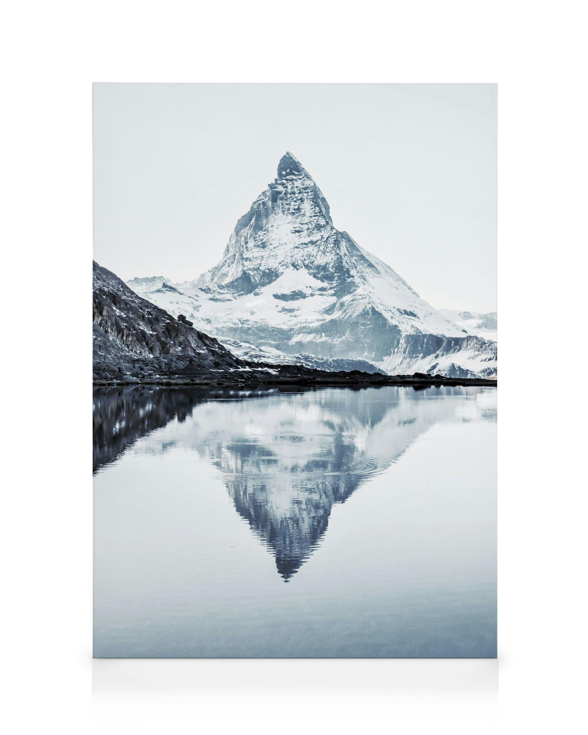 Obraz na płótnie Matterhorn, ośnieżona góra odbijająca się w spokojnej, jasnoniebieskiej wodzie.