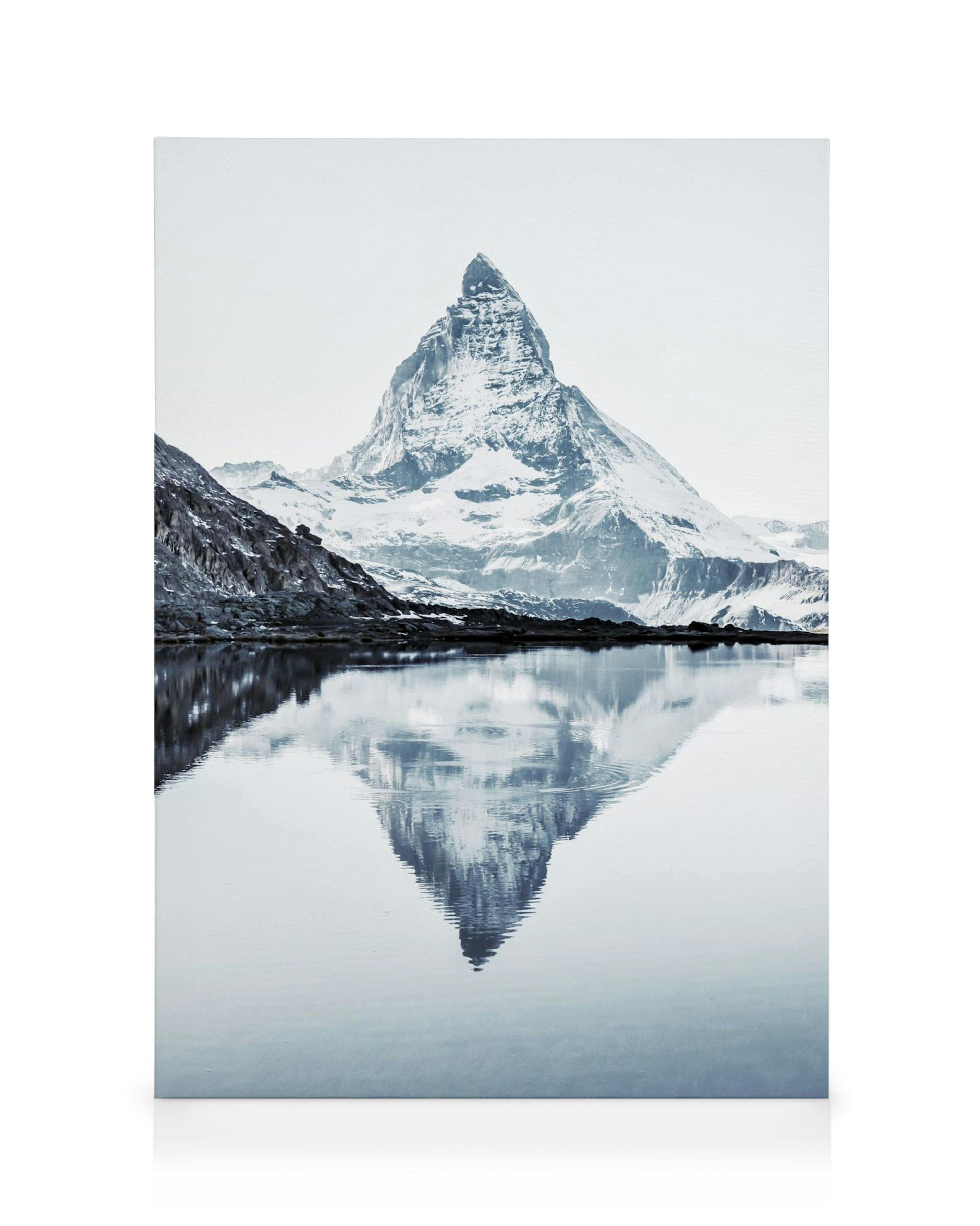 Obraz na płótnie Matterhorn, ośnieżona góra odbijająca się w spokojnej, jasnoniebieskiej wodzie.