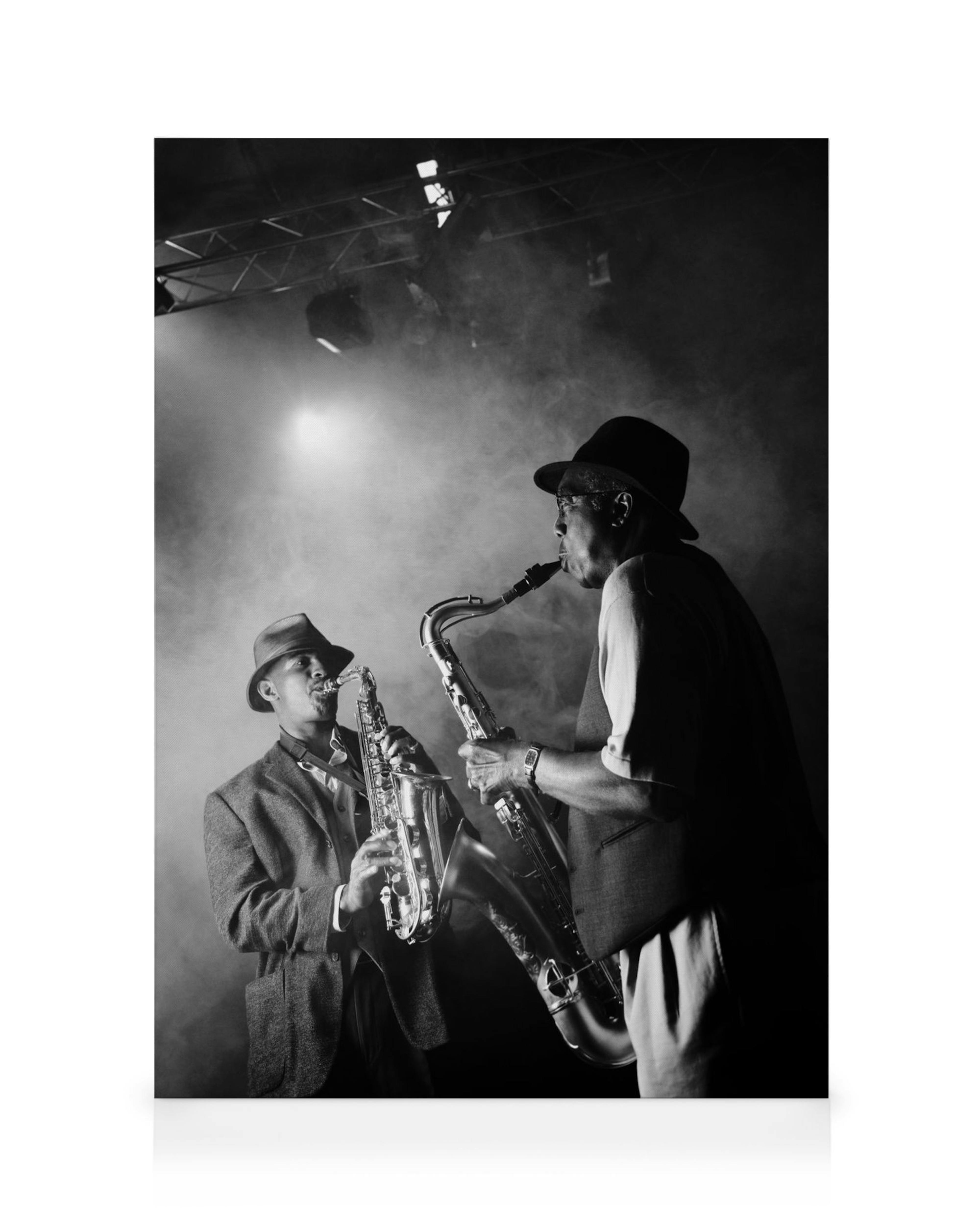 Black and white jazz club canvas of two men in fedoras playing saxophones on a smoky stage with spotlights.