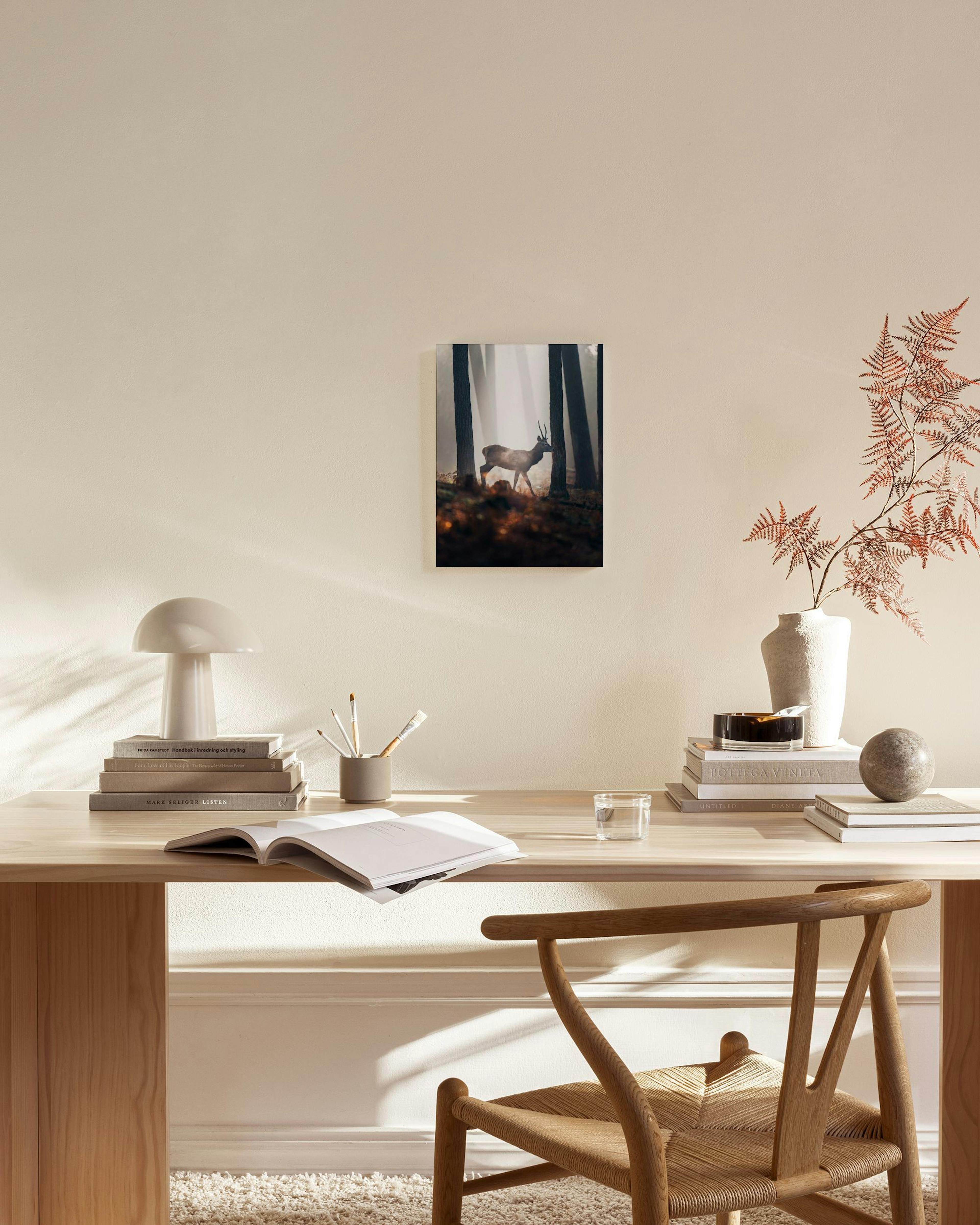 Leinwandbild eines Hirschs im nebeligen Wald, hängend über einem Sideboard in einem modernen Wohnzimmer.