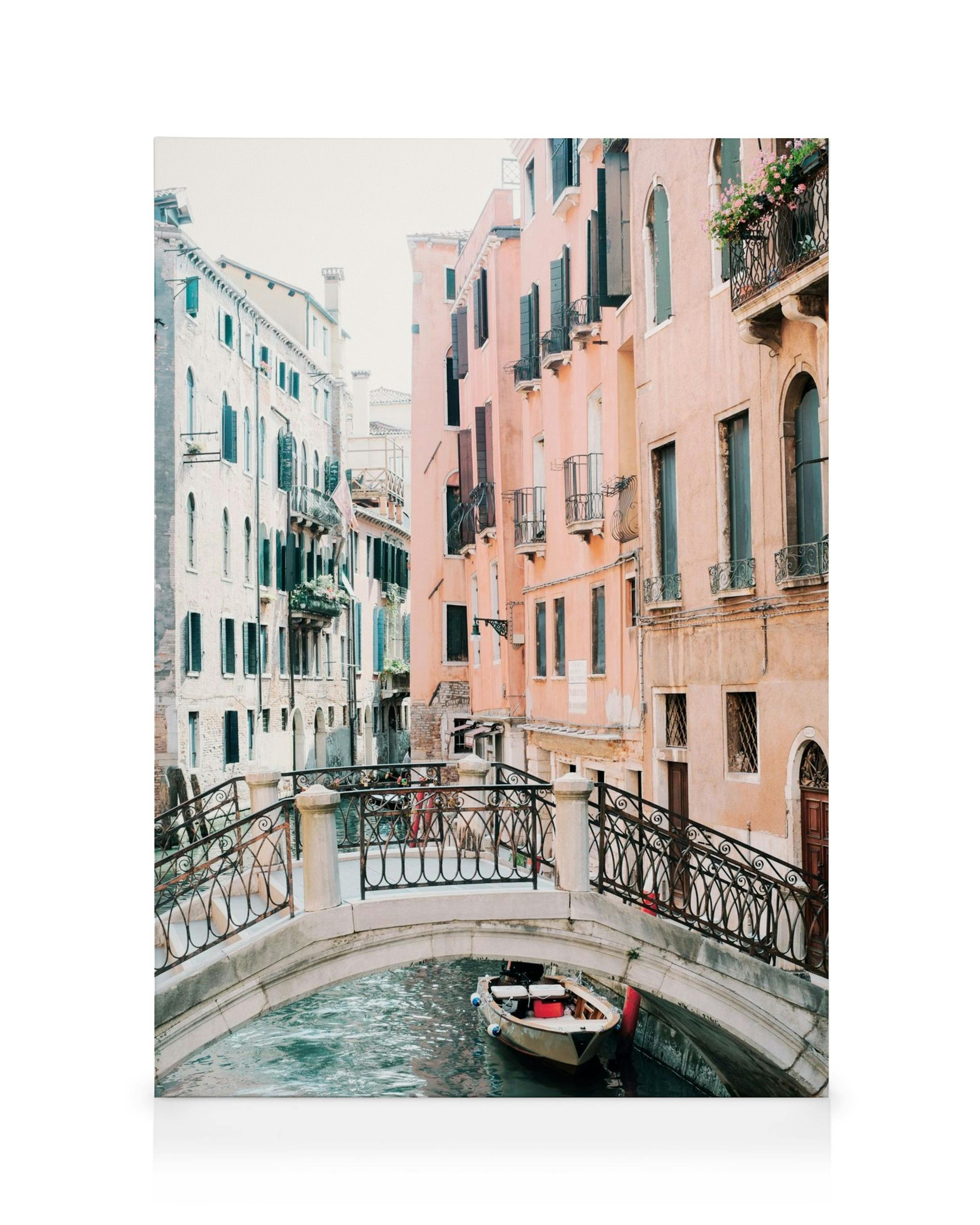 Leinwandbild von einem venezianischen Kanal mit Brücke, Boot und farbigen Häusern in hellem Licht.