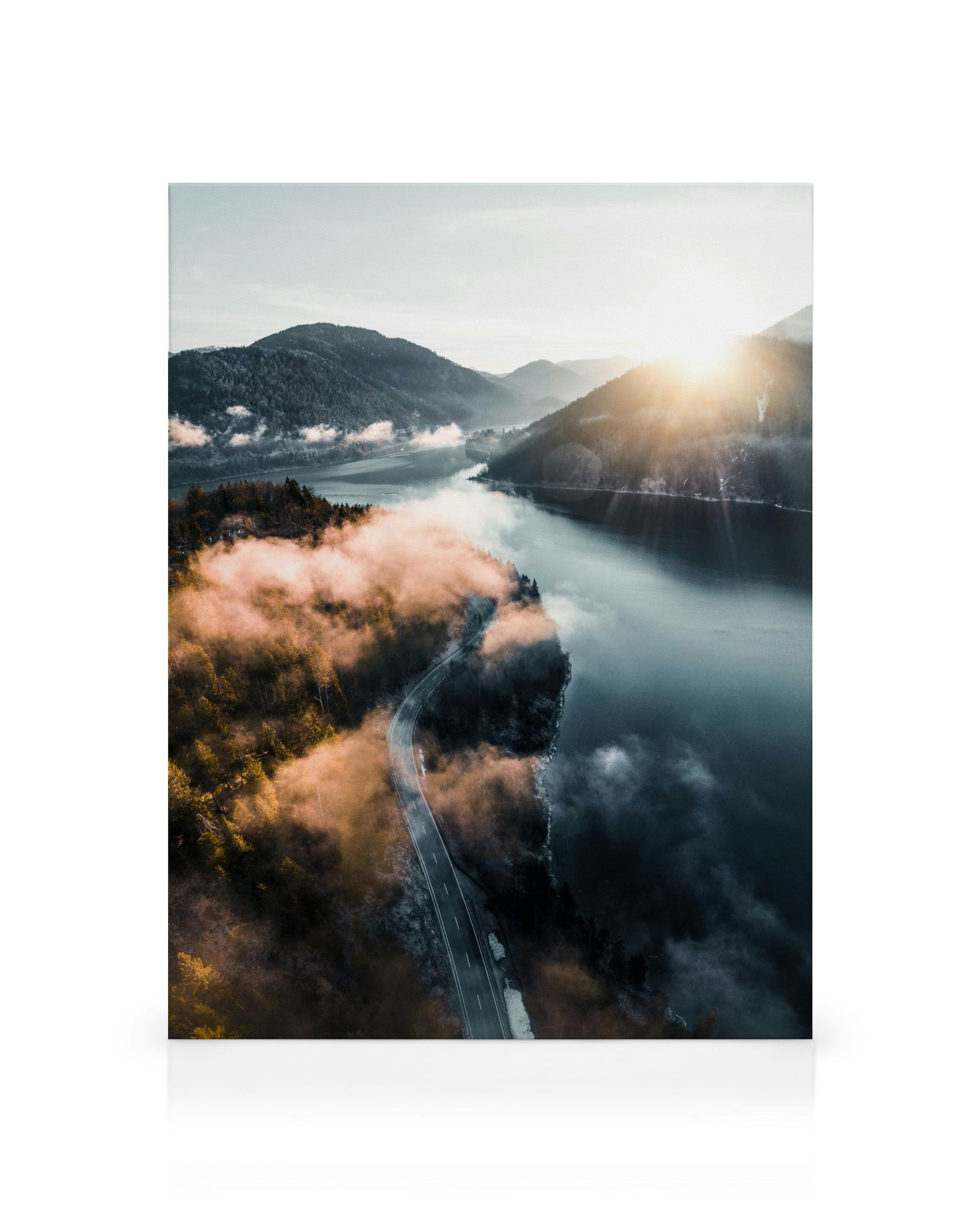 Lærred med tåge over sø og solopgang, en bjergvej langs søen, landskabskunst.