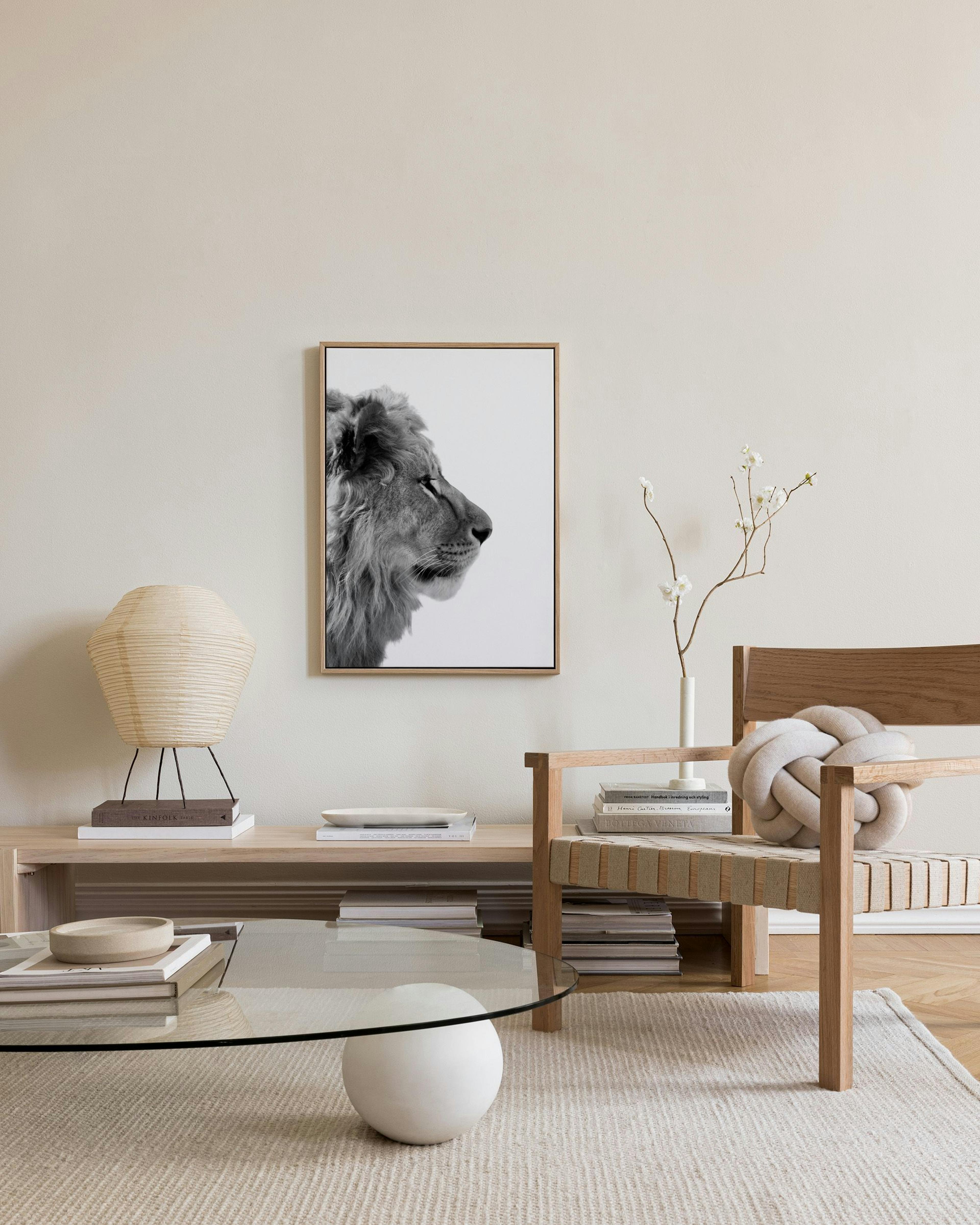 Schwarz-weiß Leinwandbild eines Löwen im Profil, hängend über einem Sideboard in einem Wohnzimmer.