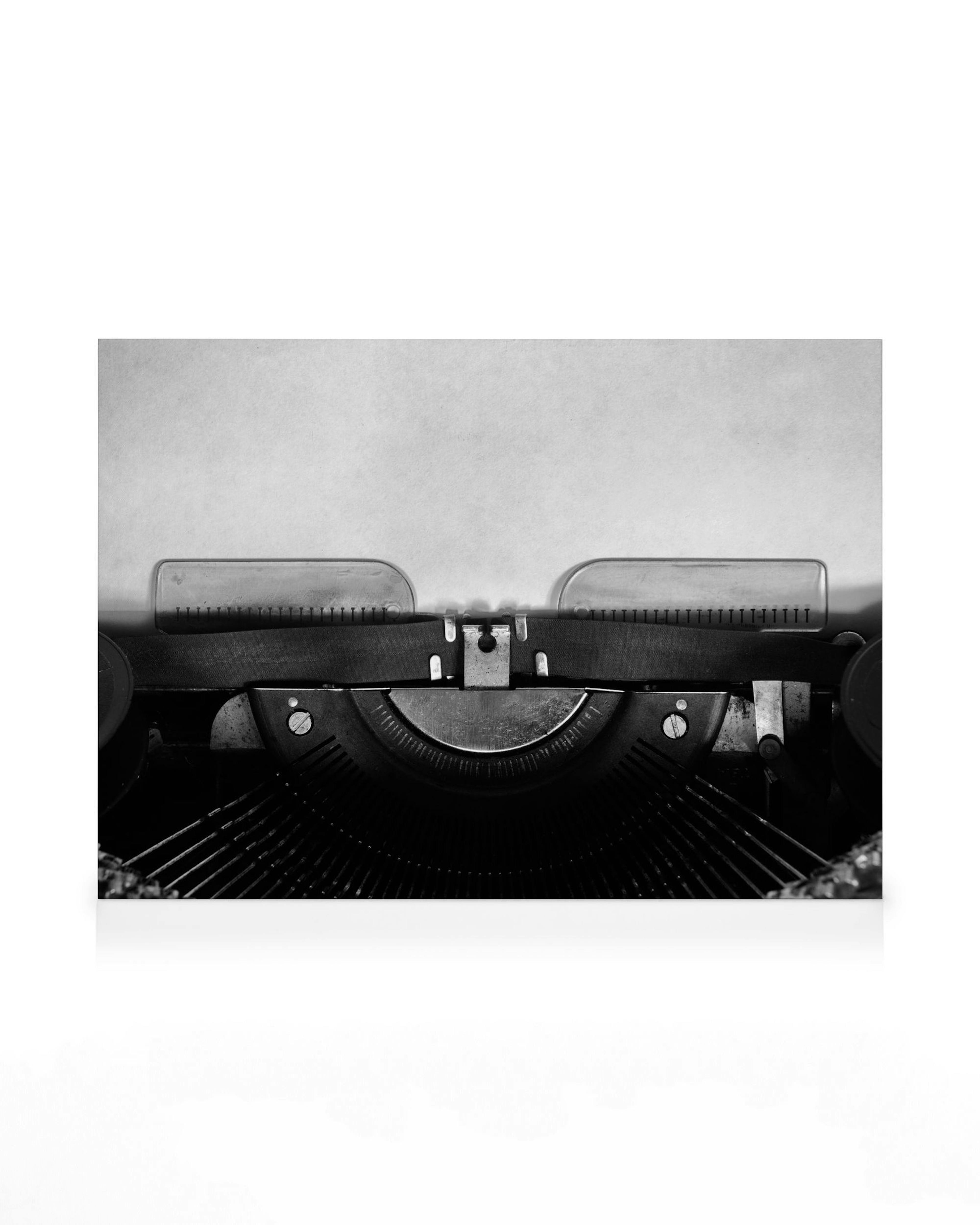 Black and white vintage typewriter with a blank page for writing on a canvas print.