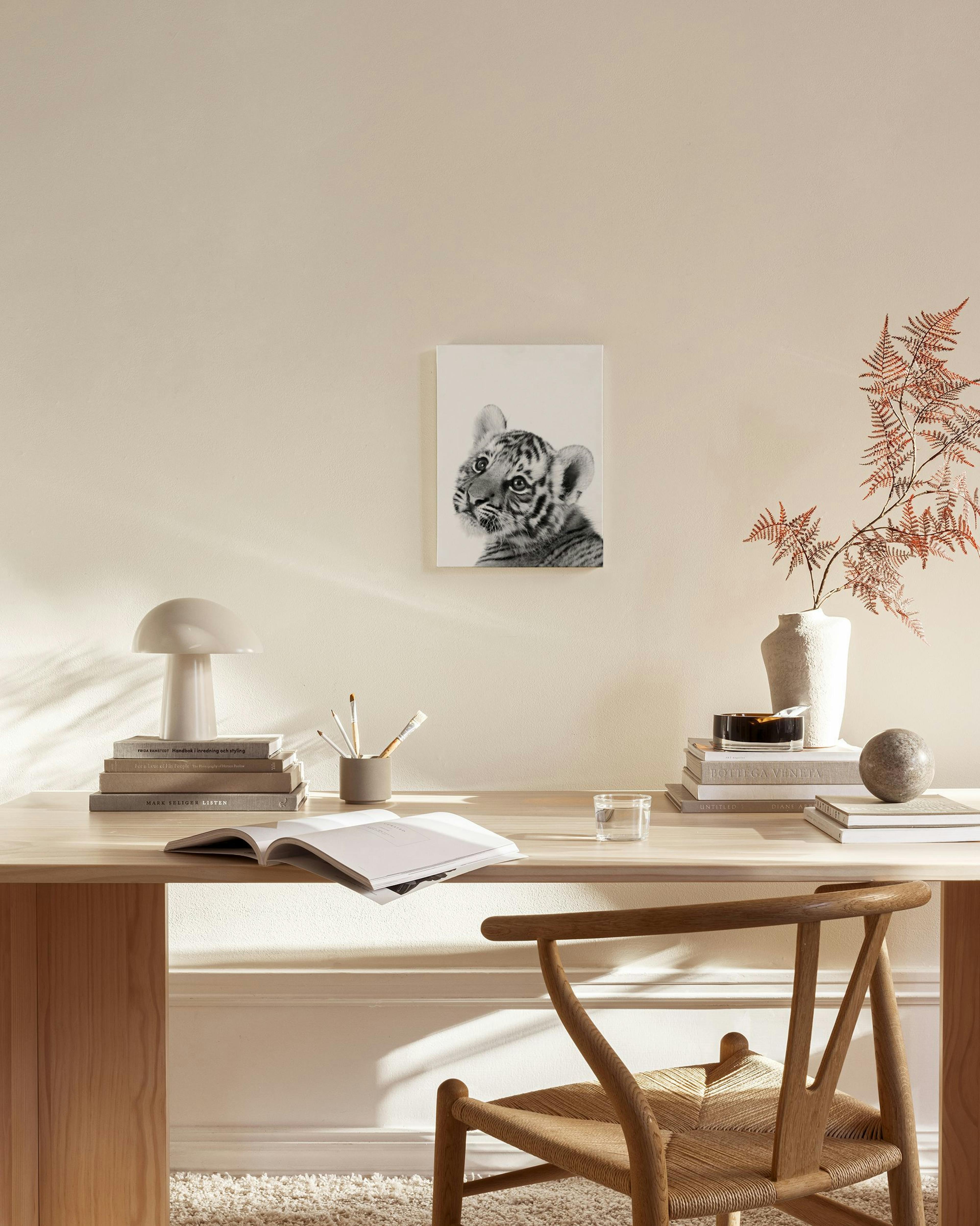 A stunning canvas print of a curious baby tiger in black and white, hanging in a bright, minimalist living room.