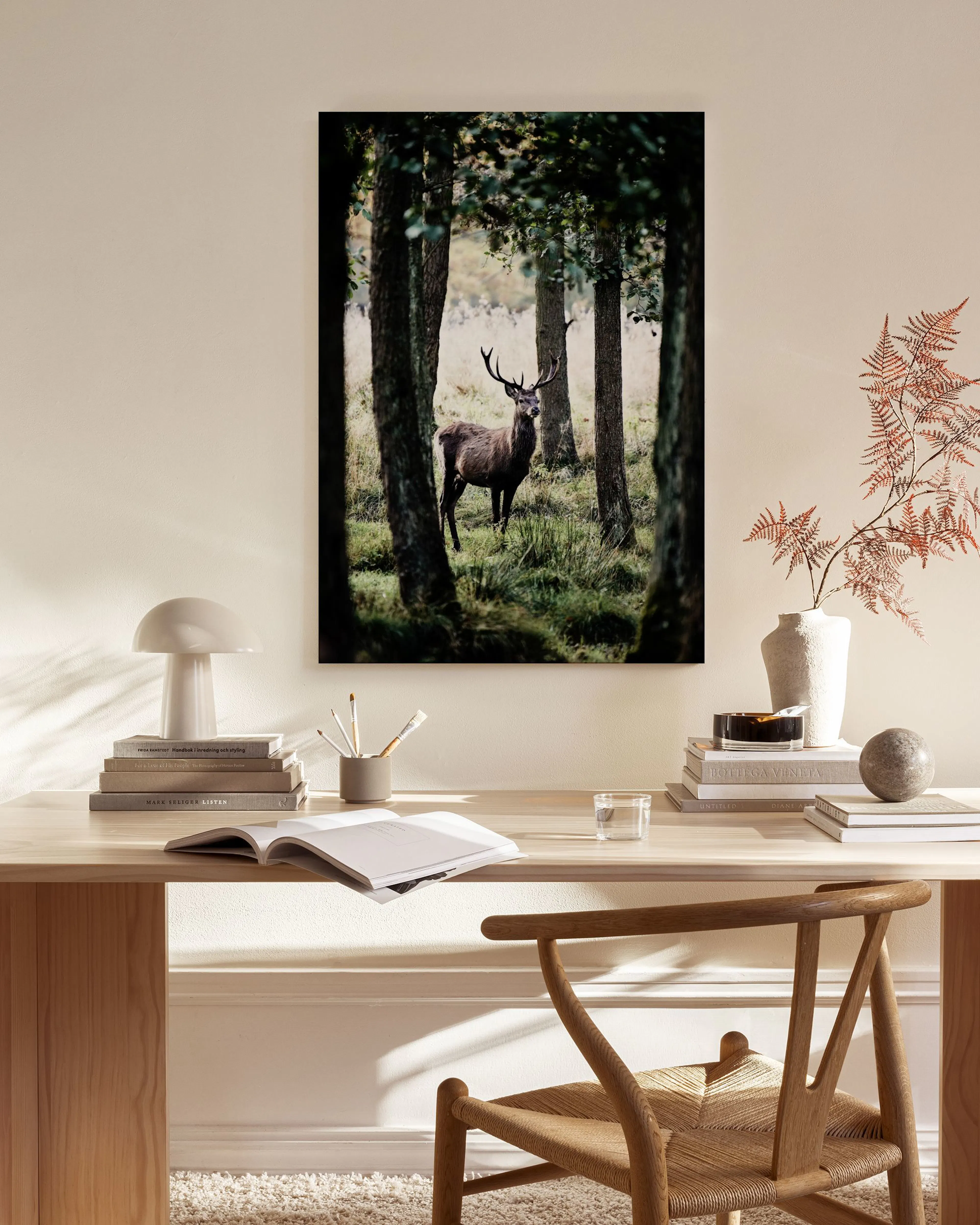 Leinwandbild eines Hirsches im Wald, aufgehängt in einem minimalistischen Wohnzimmer über einem Sideboard.