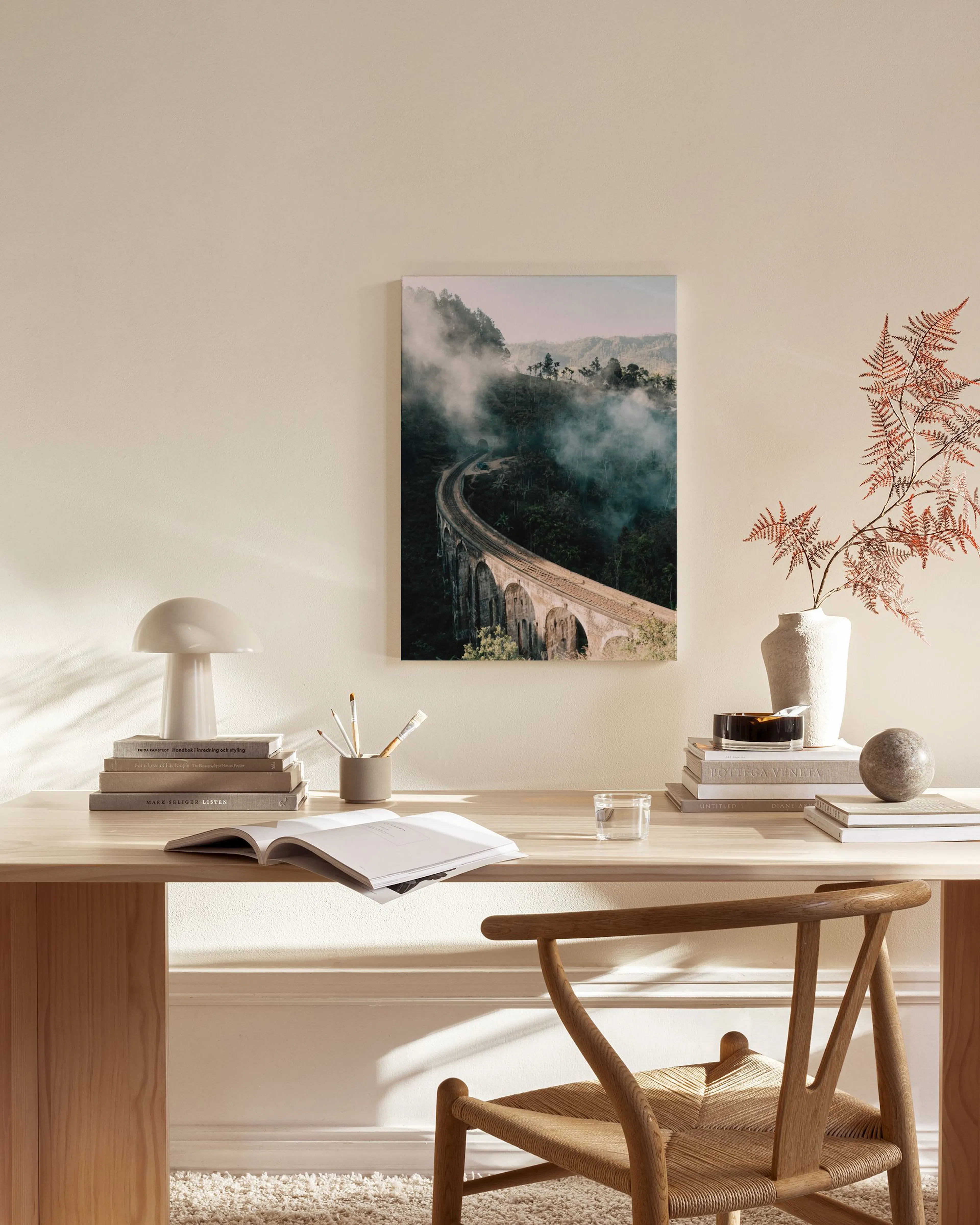 Canvas van een mistige stenen brug in een groene vallei, hangend in een neutrale woonkamer.