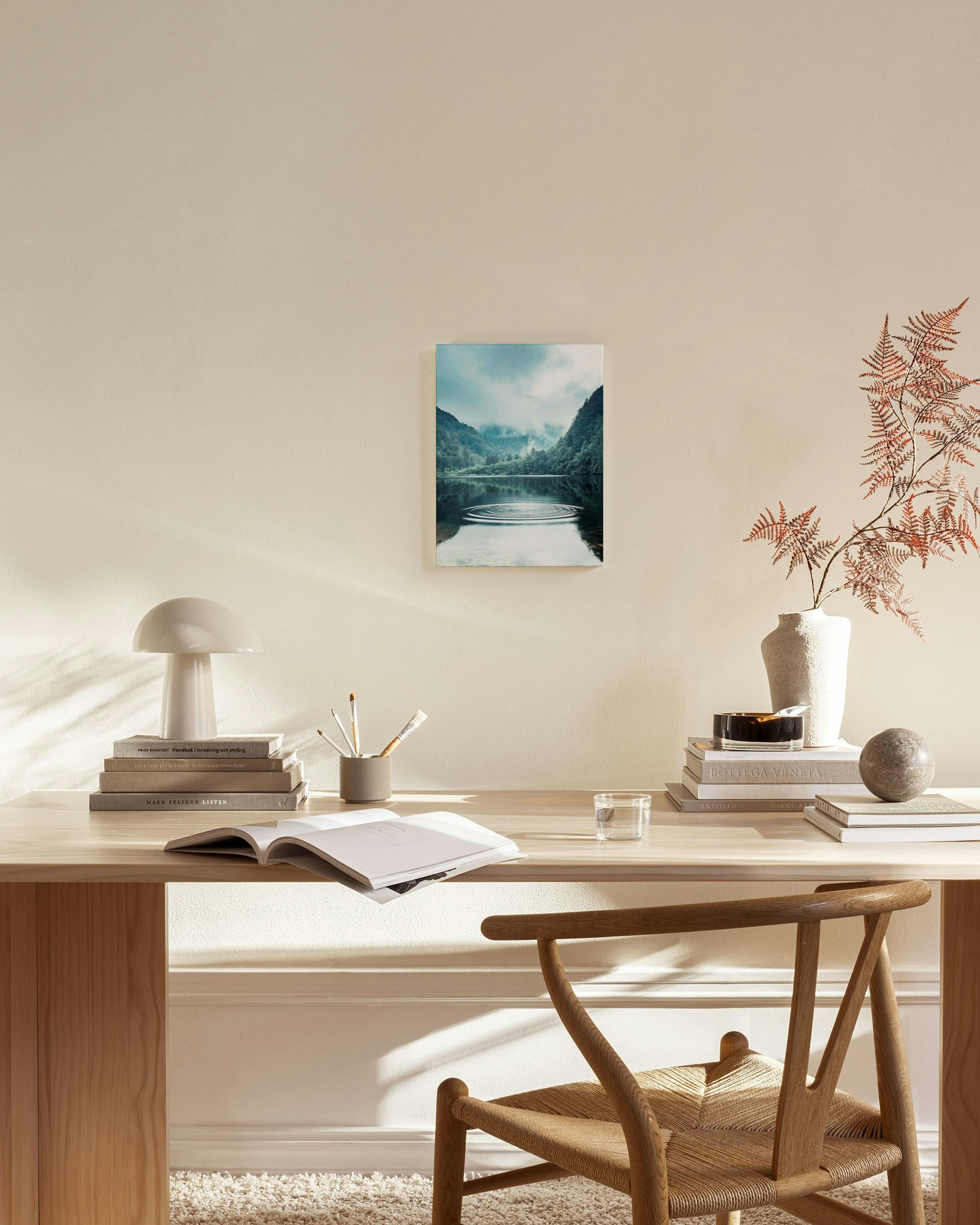 Toile dun lac de montagne brumeux avec des ronds dans leau, affichée dans un salon moderne.
