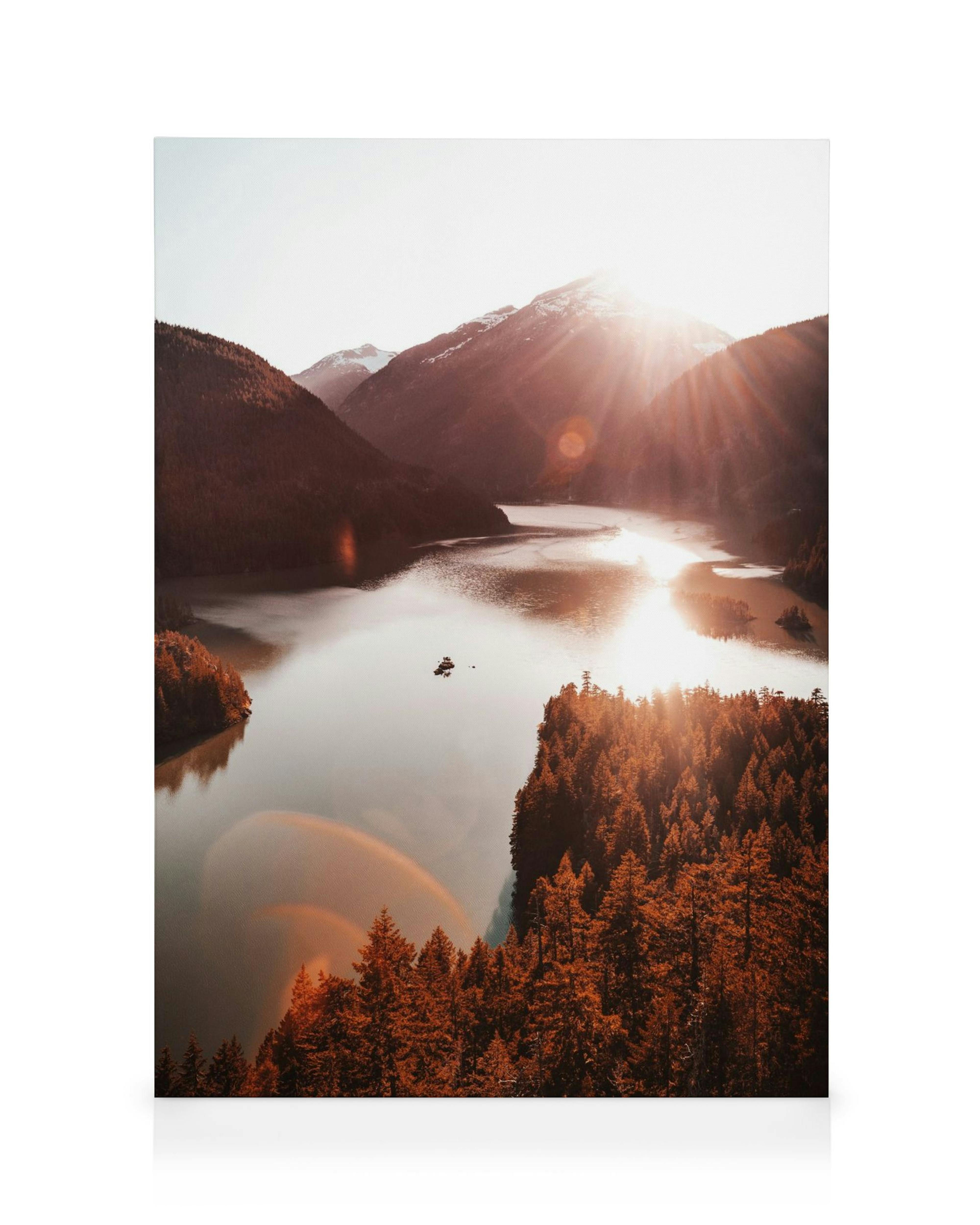 Jezero Diablo při západu slunce s červenými stromy a horami, záře slunce na hladině vody.