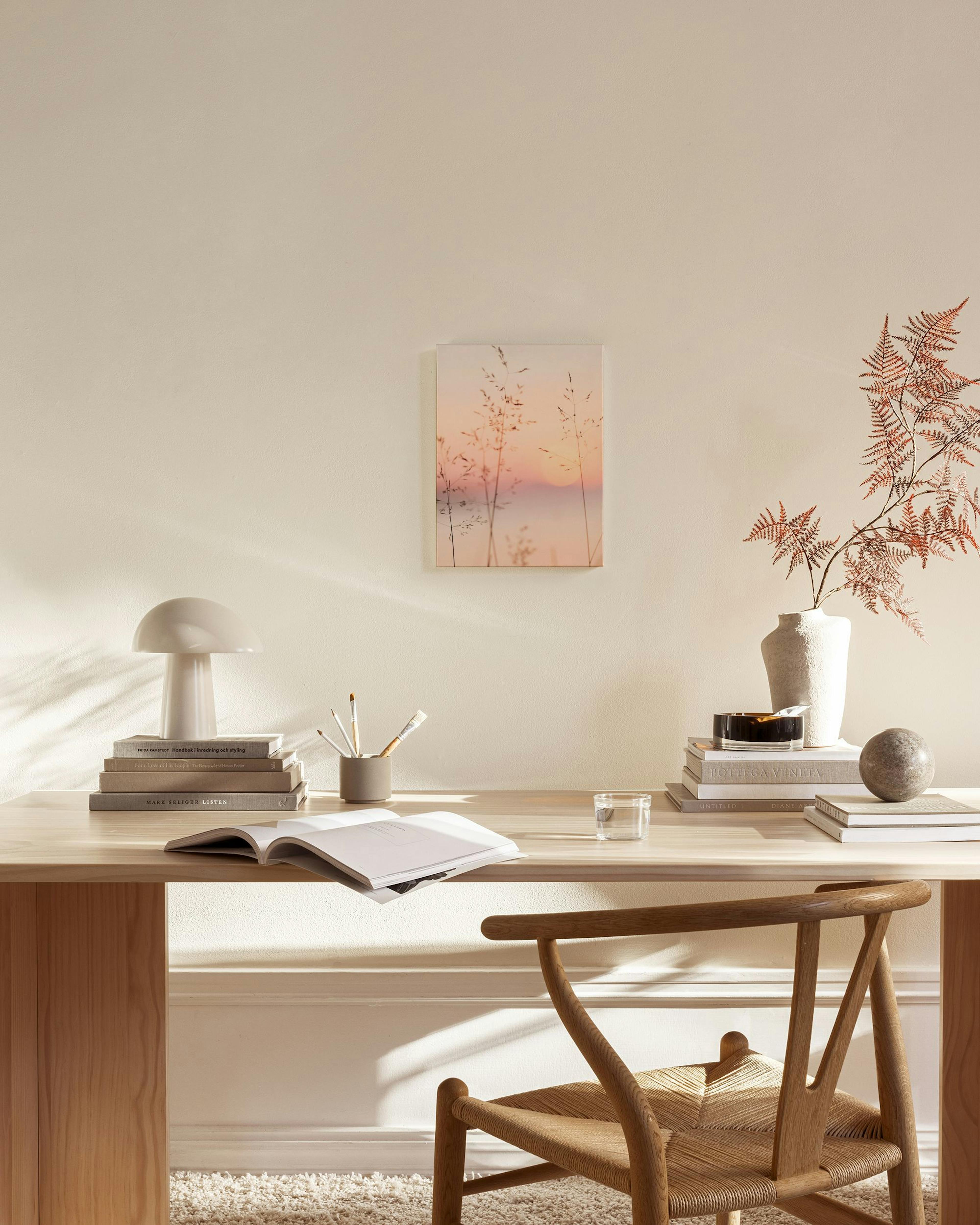 Toile herbes hautes au lever du soleil rose, suspendue au-dessus dun banc dans un salon moderne.