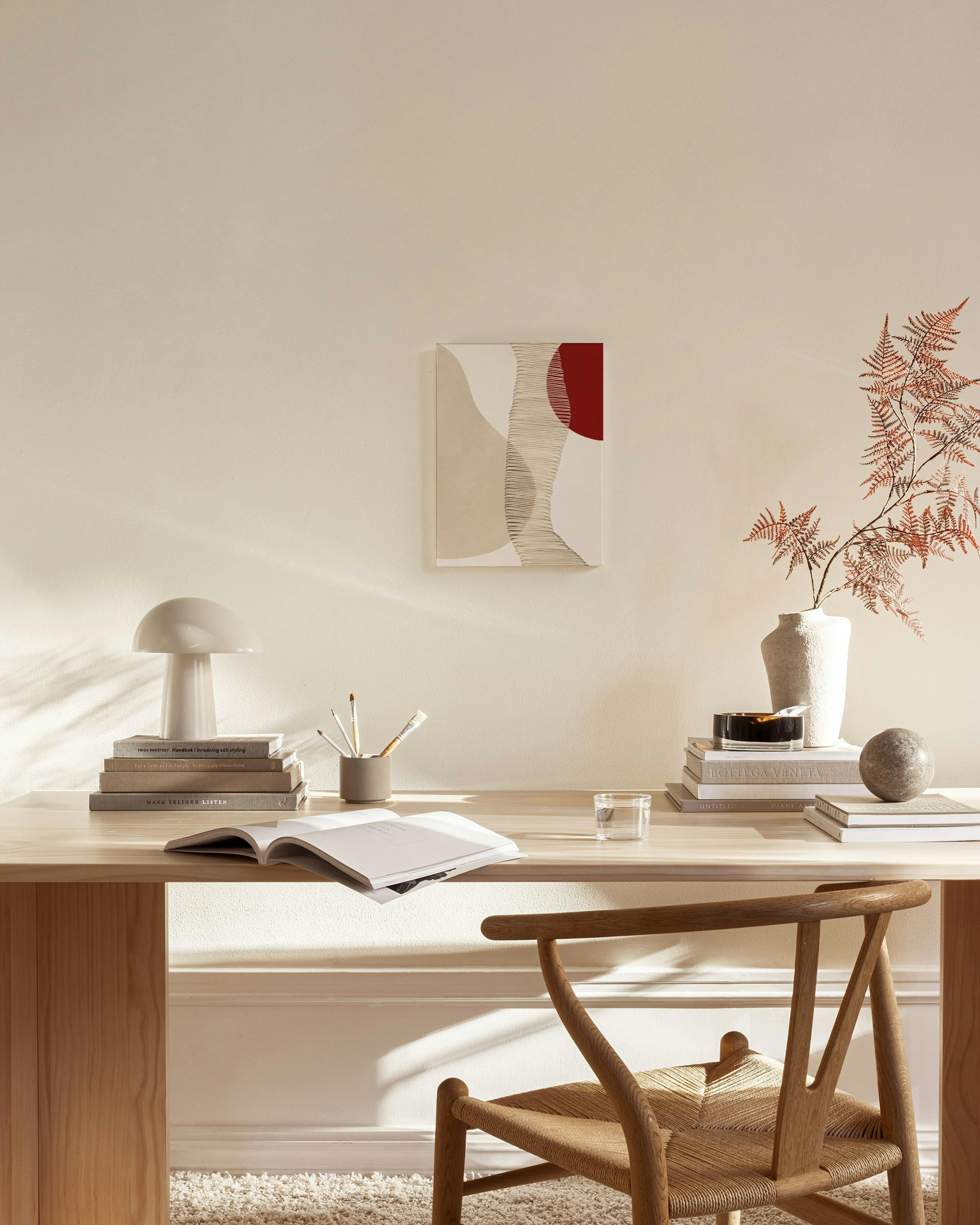 Abstract canvas print with red, beige, and white organic shapes and thin lines, displayed in a modern living room.