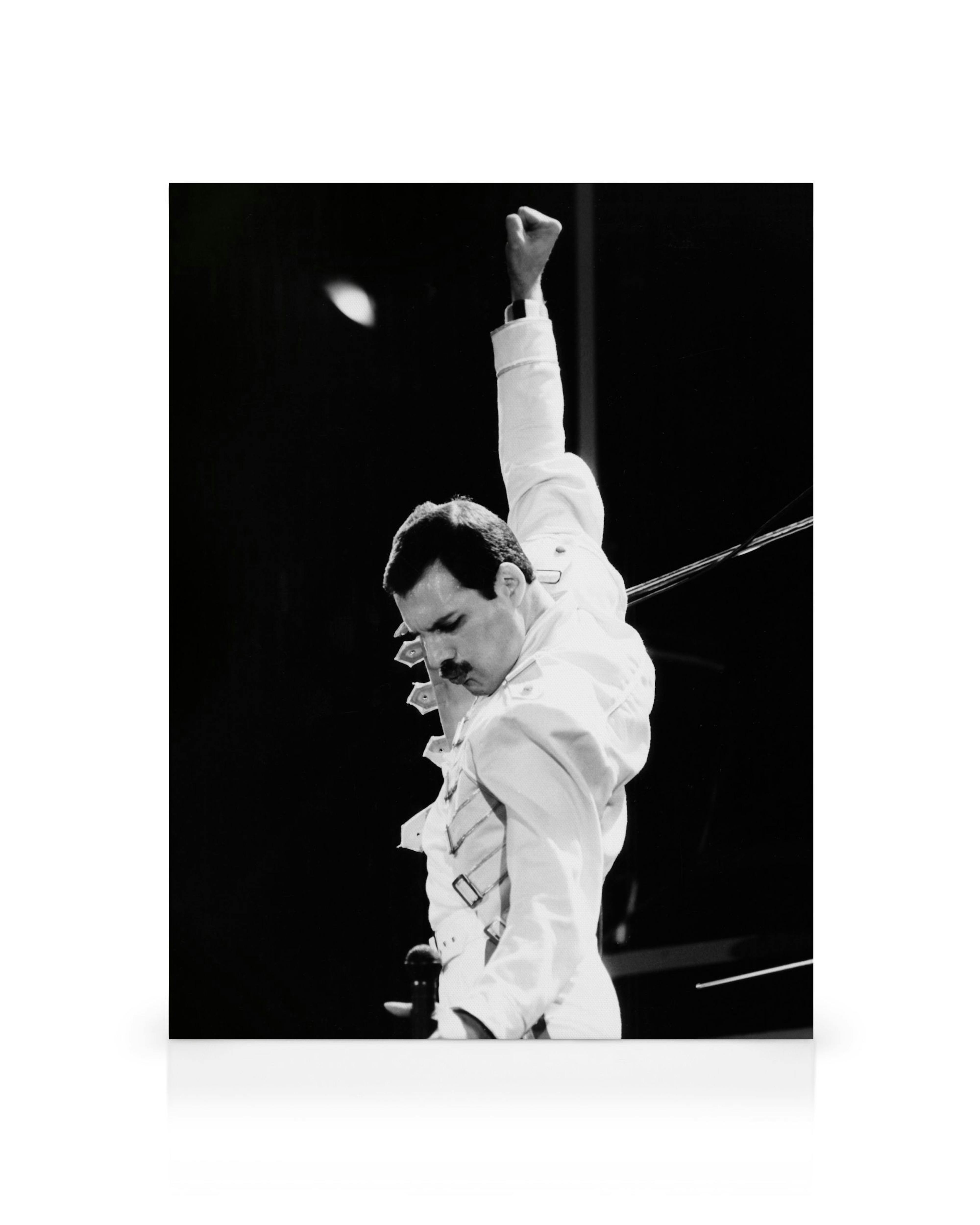 A monochromatic canvas print of Freddie Mercury with his fist raised, wearing a white military-style jacket.