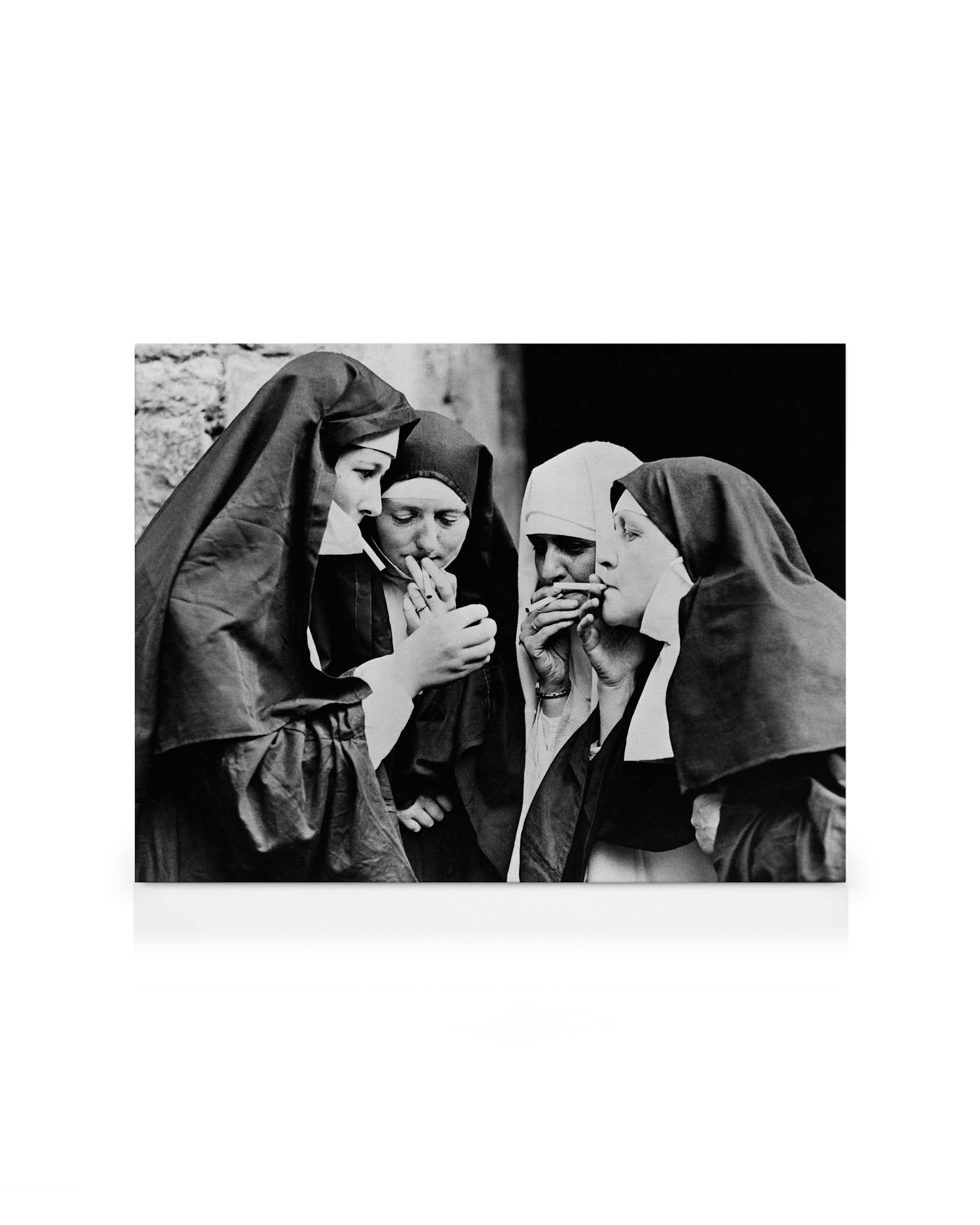 A black and white canvas print showing a group of nuns smoking cigarettes, some lighting up.